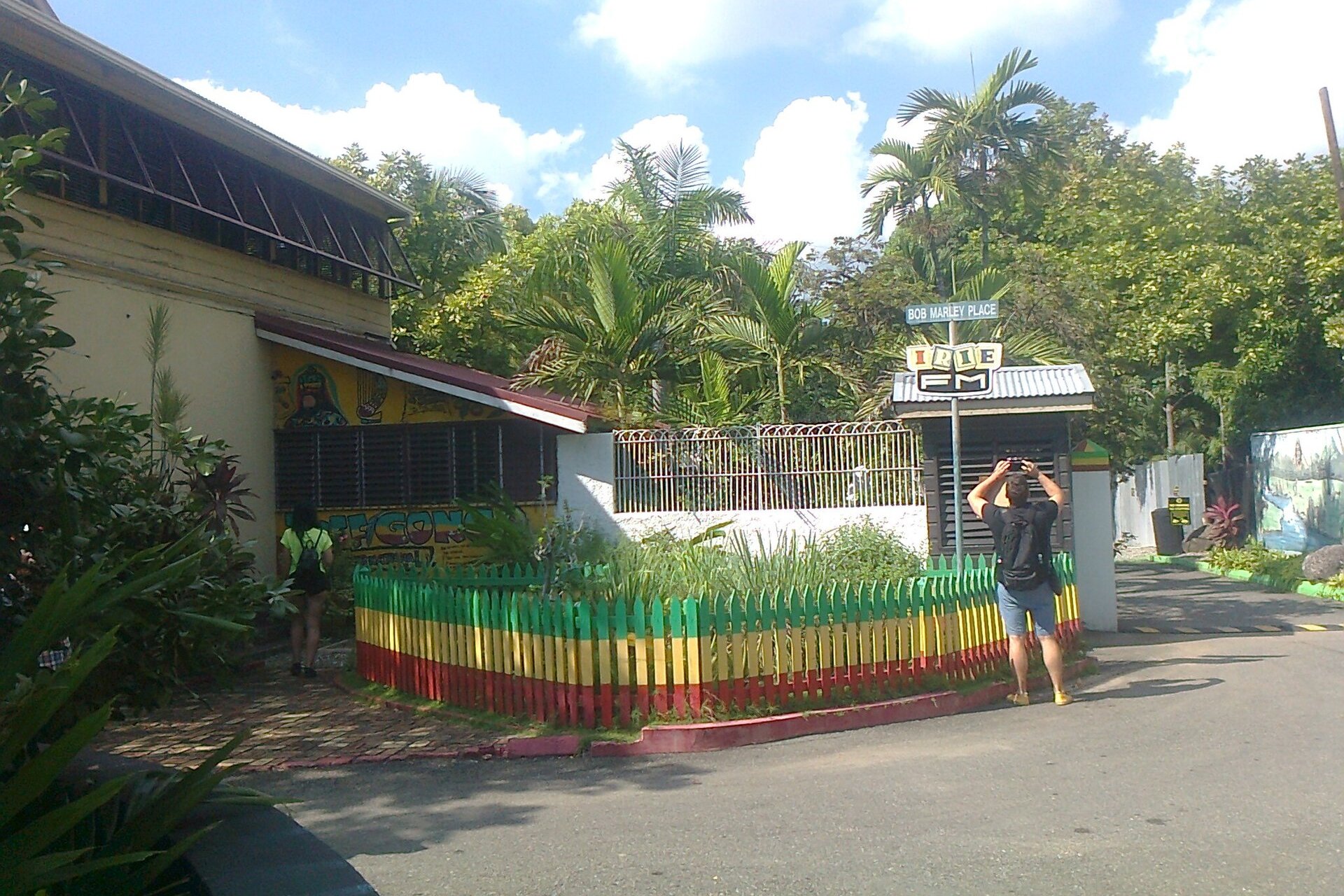 Rastafari-coloured fence and a Bob Marley Place street sign on Hope Road in Kingston, Jamaica