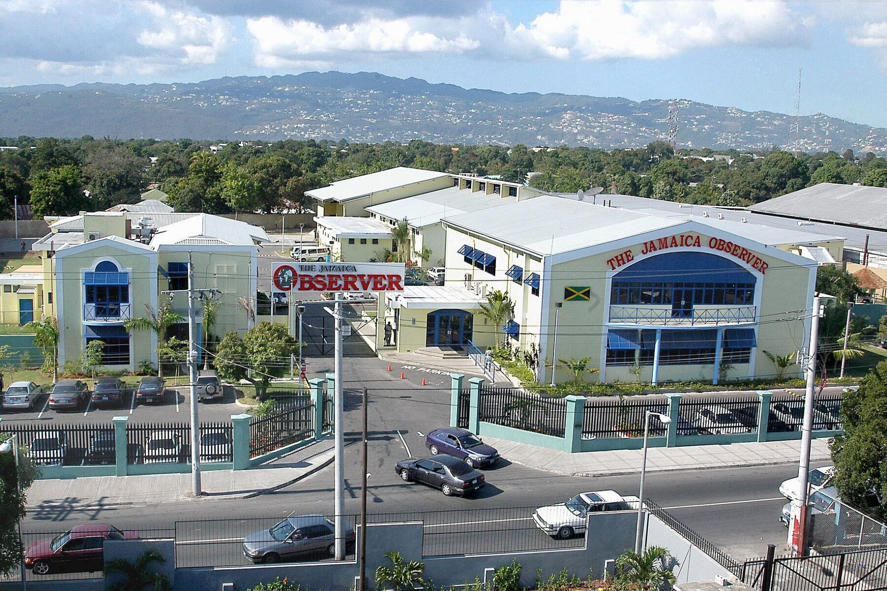 Aerial view of the Jamaica Observer headquarters in Kingston, Jamaica, with hills behind the city