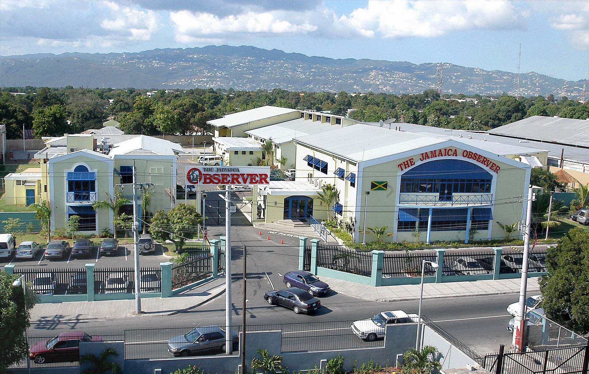 Aerial view of the Jamaica Observer headquarters in Kingston, Jamaica, with hills behind the city
