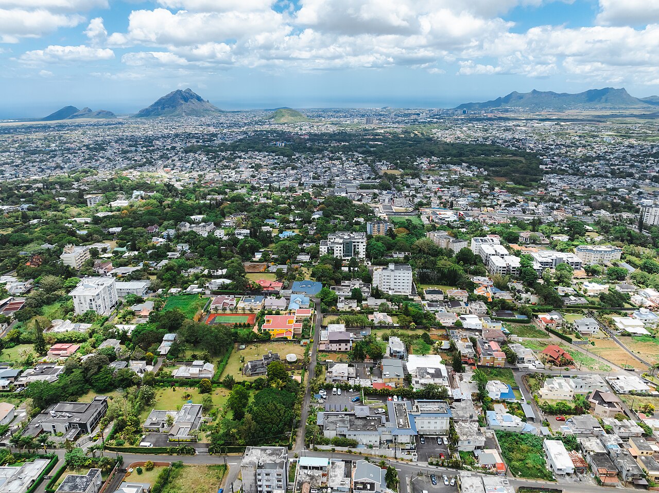 Aerial view of the town of Vacoas-Phoenix on the central plateau of Mauritius with mountains in the distance.
