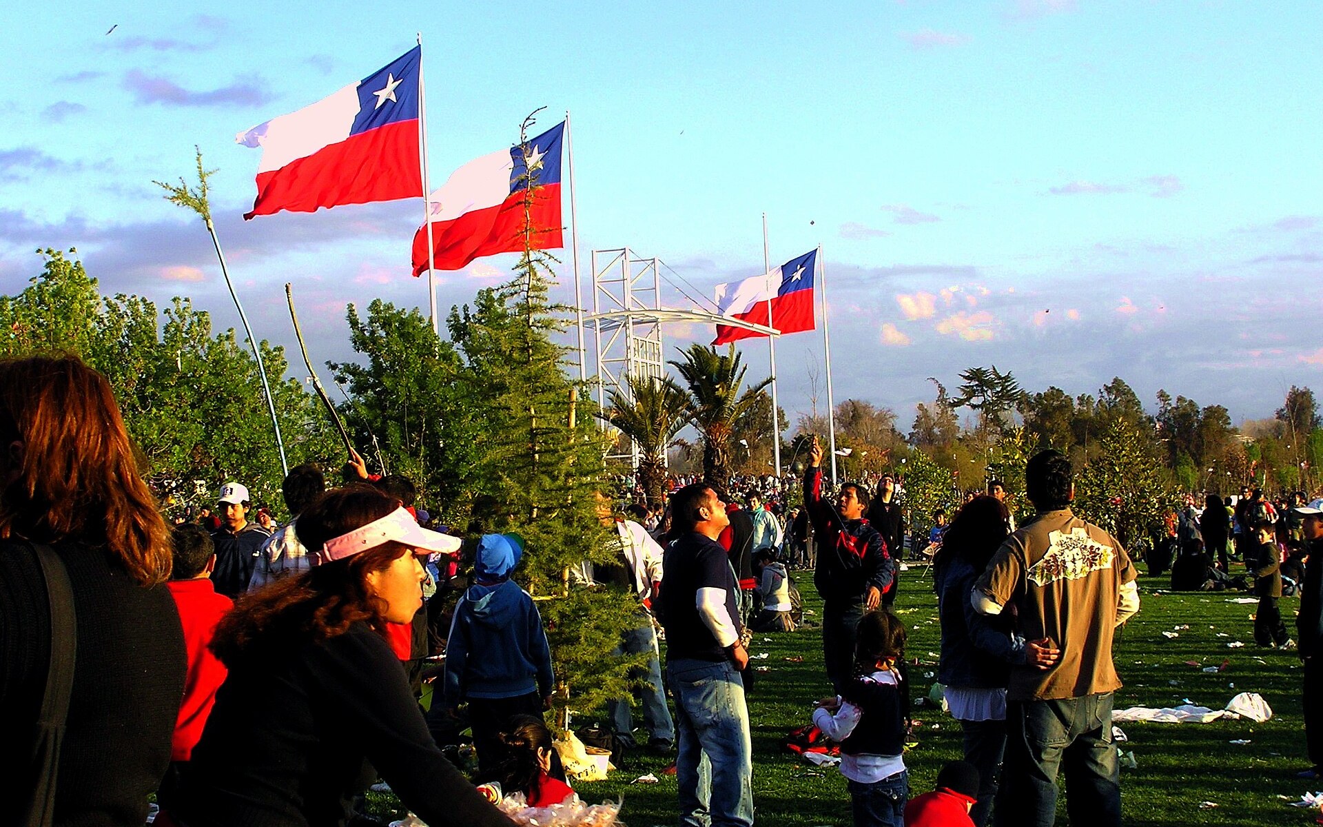 Families and Chilean flags on the lawns of Parque O'Higgins in Santiago, Chile, on a sunny afternoon