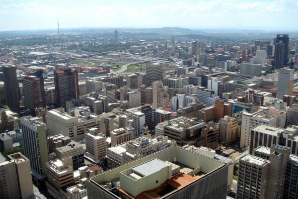 Aerial view of office towers and streets in central Johannesburg with the Hillbrow tower on the horizon