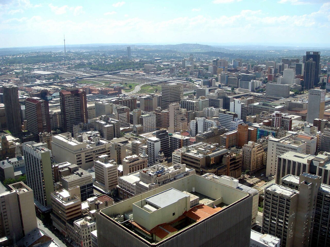 Aerial view of office towers and streets in central Johannesburg with the Sentech Tower on the horizon