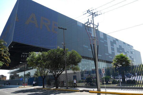 The Arena Ciudad de México in Azcapotzalco, Mexico City, seen from the street, with the building's name in lit letters on the upper wall.