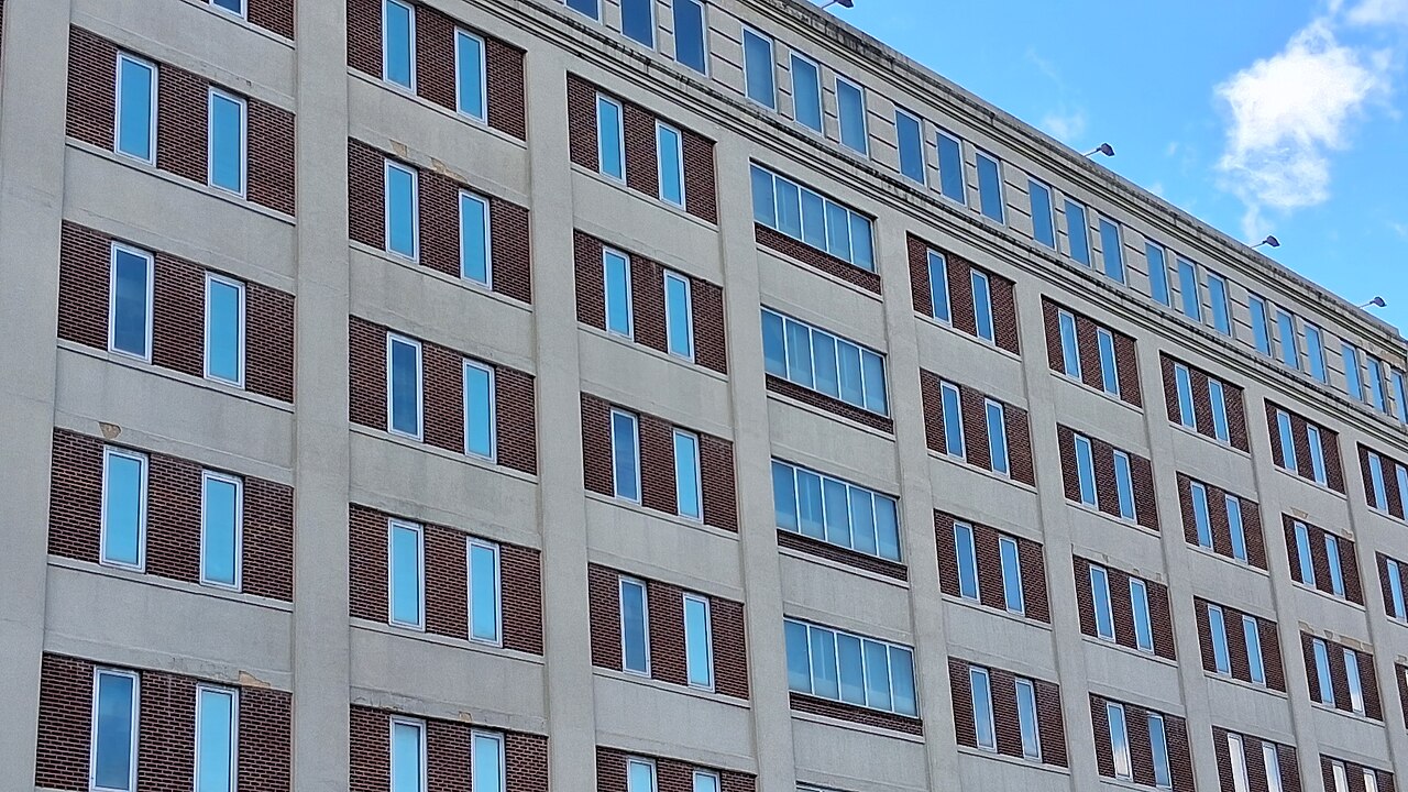 Brick and concrete facade of the Metropolitan Detention Center in Brooklyn under a blue sky