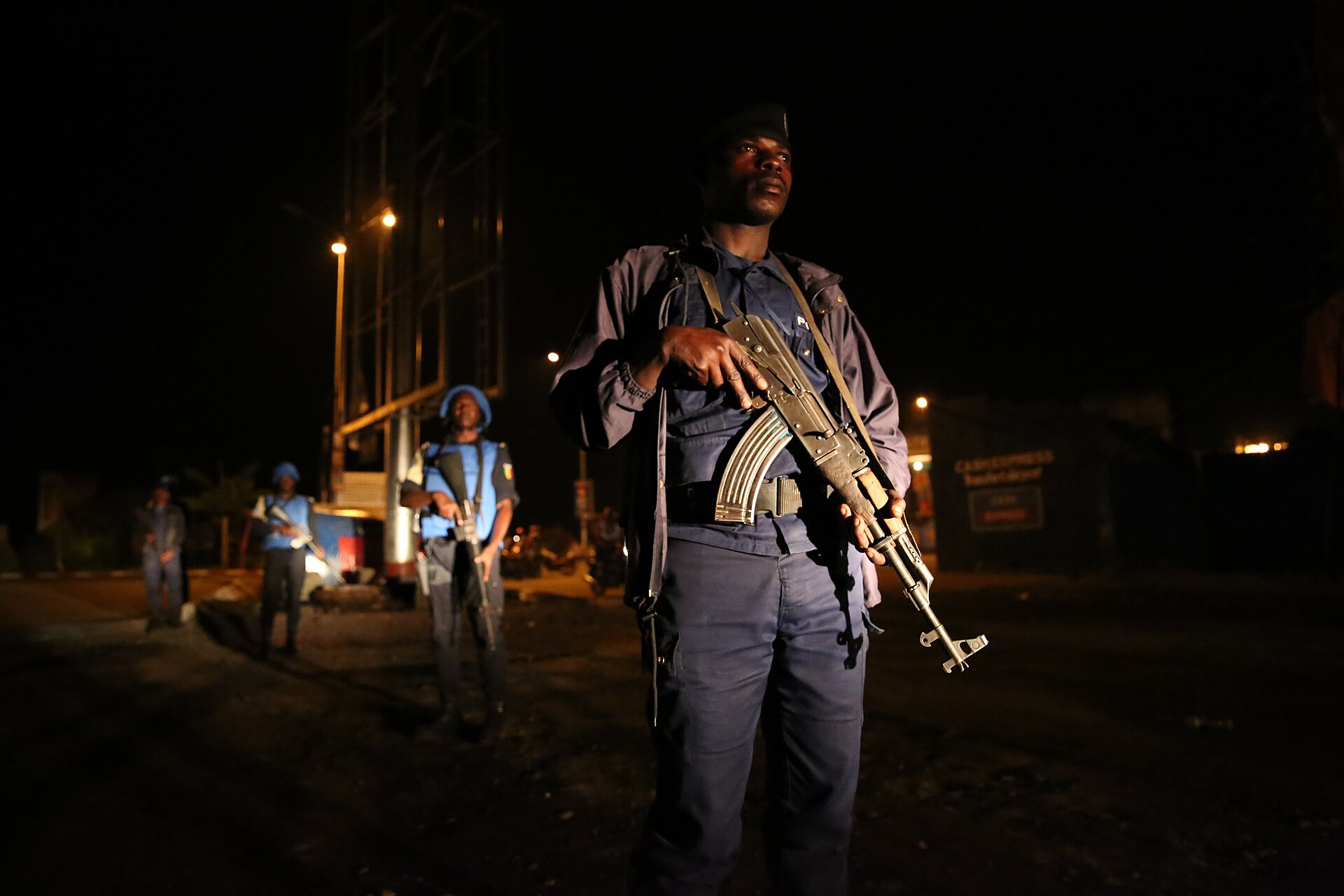 A Congolese National Police officer on a night patrol in Goma, North Kivu, with UN police behind him
