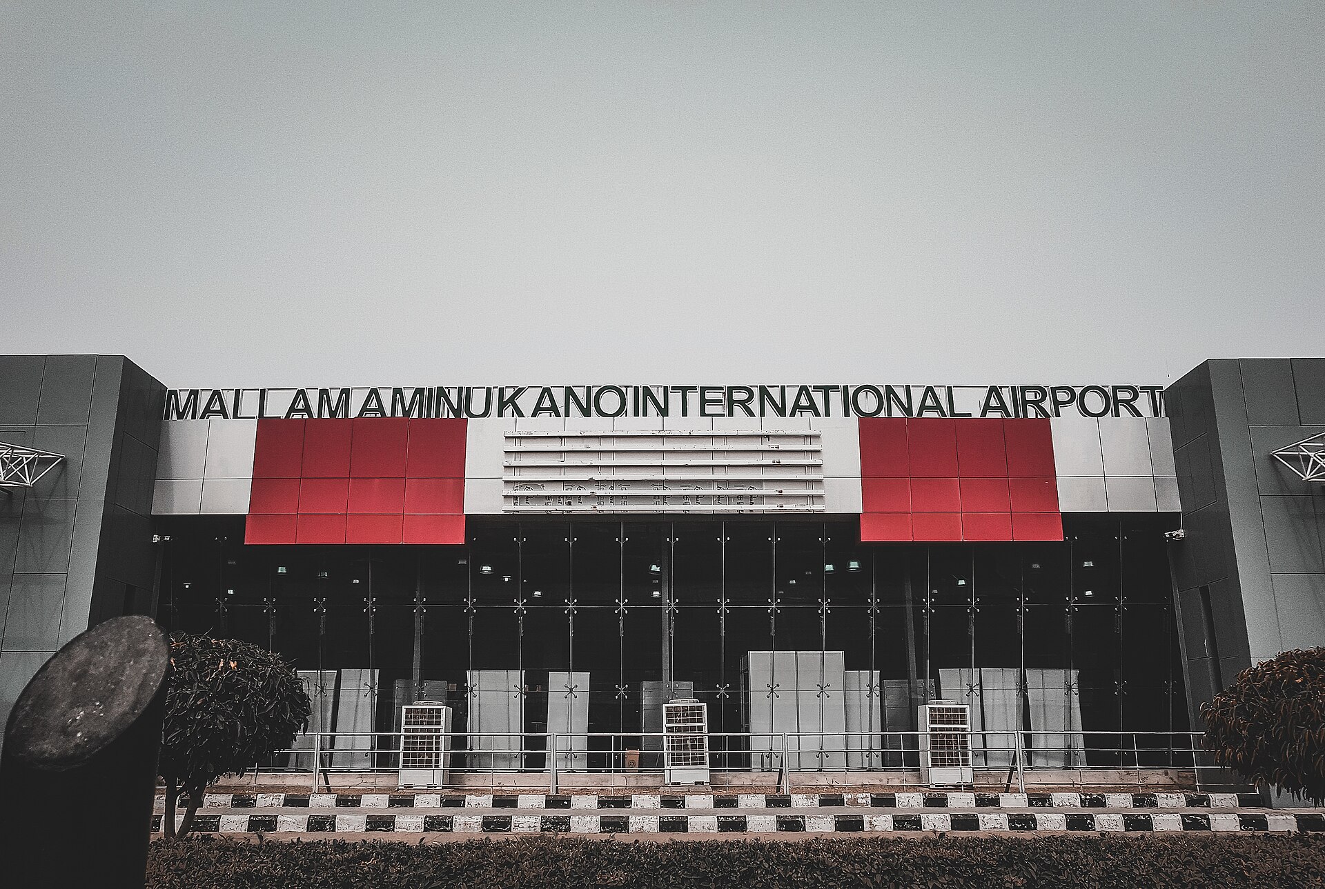 The passenger terminal of Mallam Aminu Kano International Airport in Kano, with its name in large letters above red and grey panels