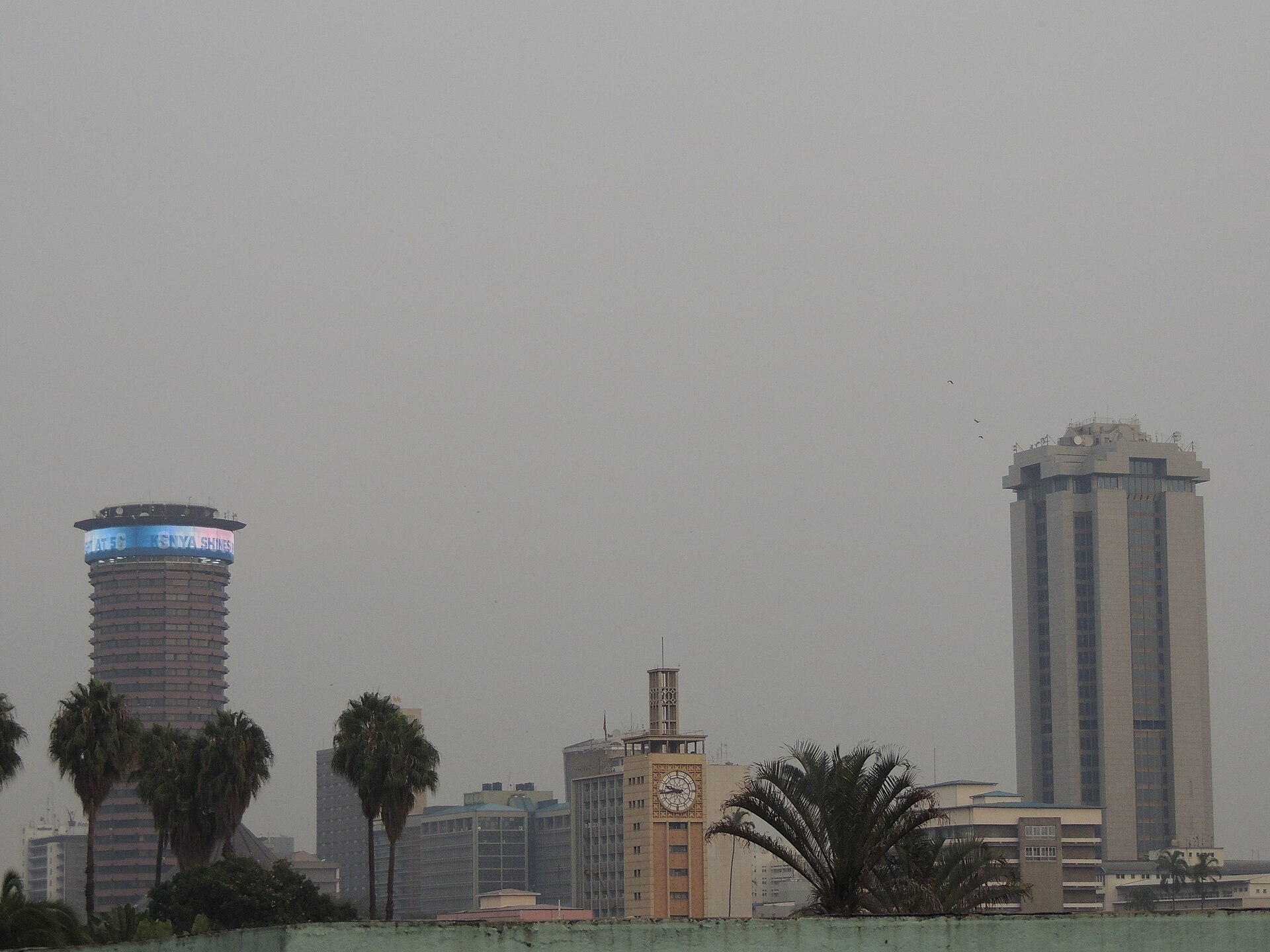 Central Nairobi buildings under a hazy sky, with the Kenyatta International Convention Centre tower at left