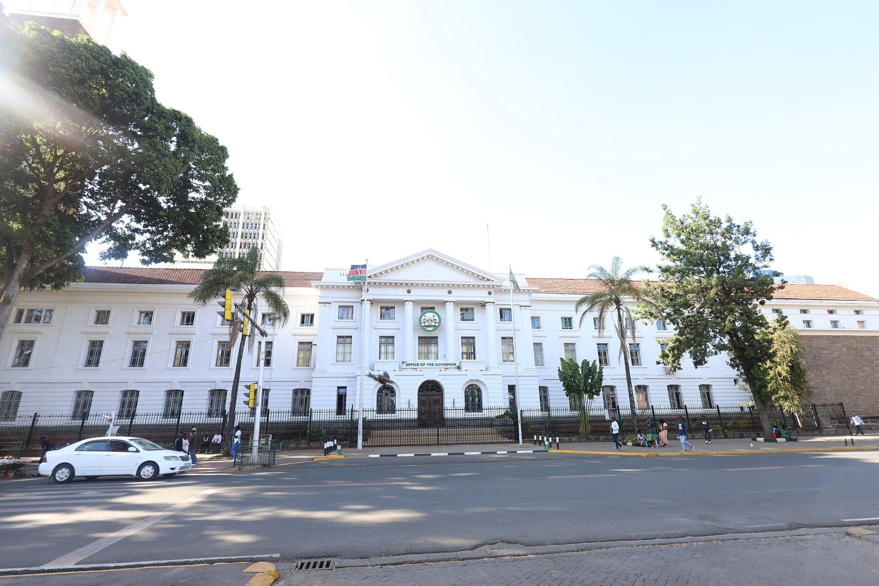 A white colonial-style building in central Nairobi with an Office of the Governor sign and the Kenyan flag