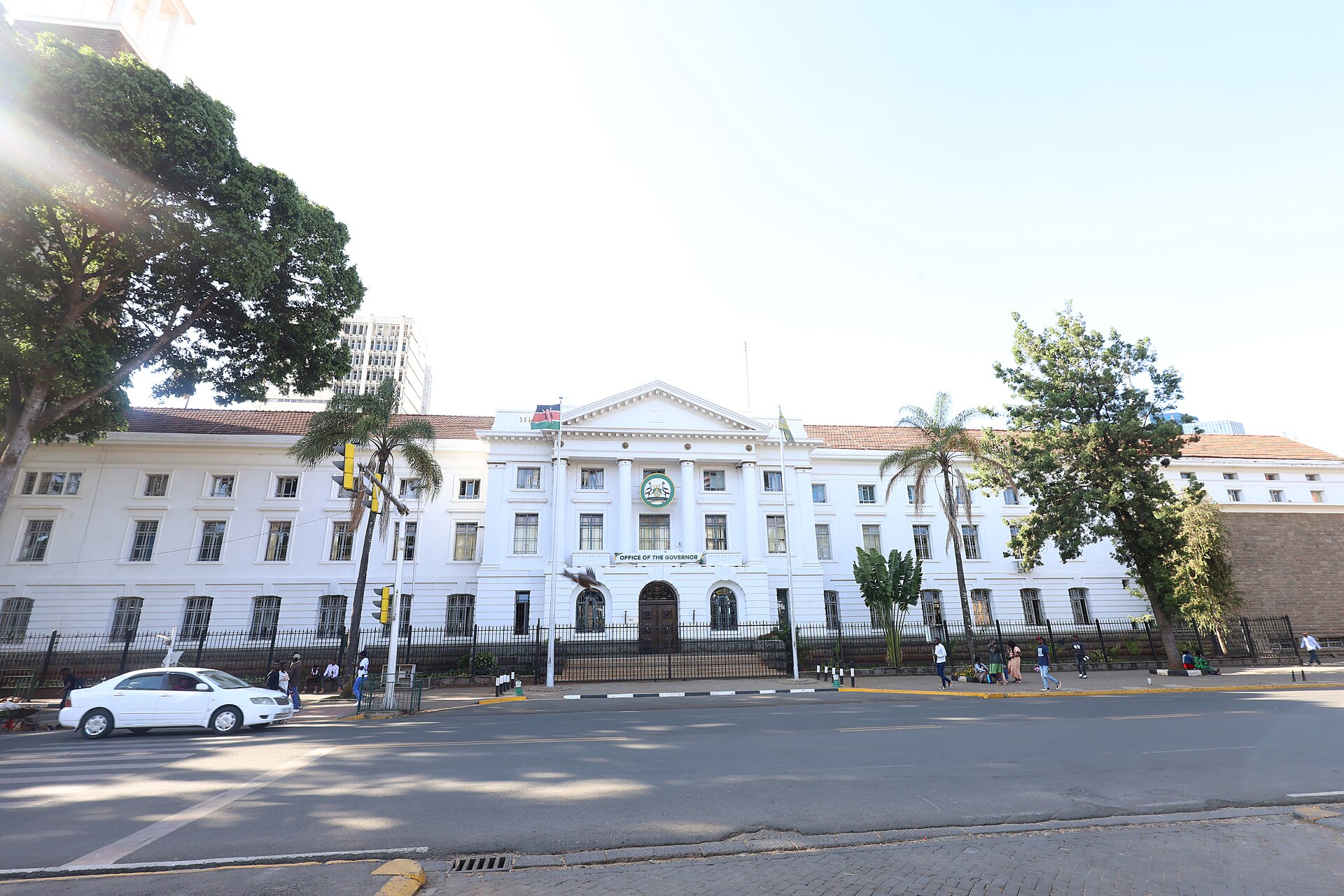 A white colonial-style building in central Nairobi with an Office of the Governor sign and the Kenyan flag
