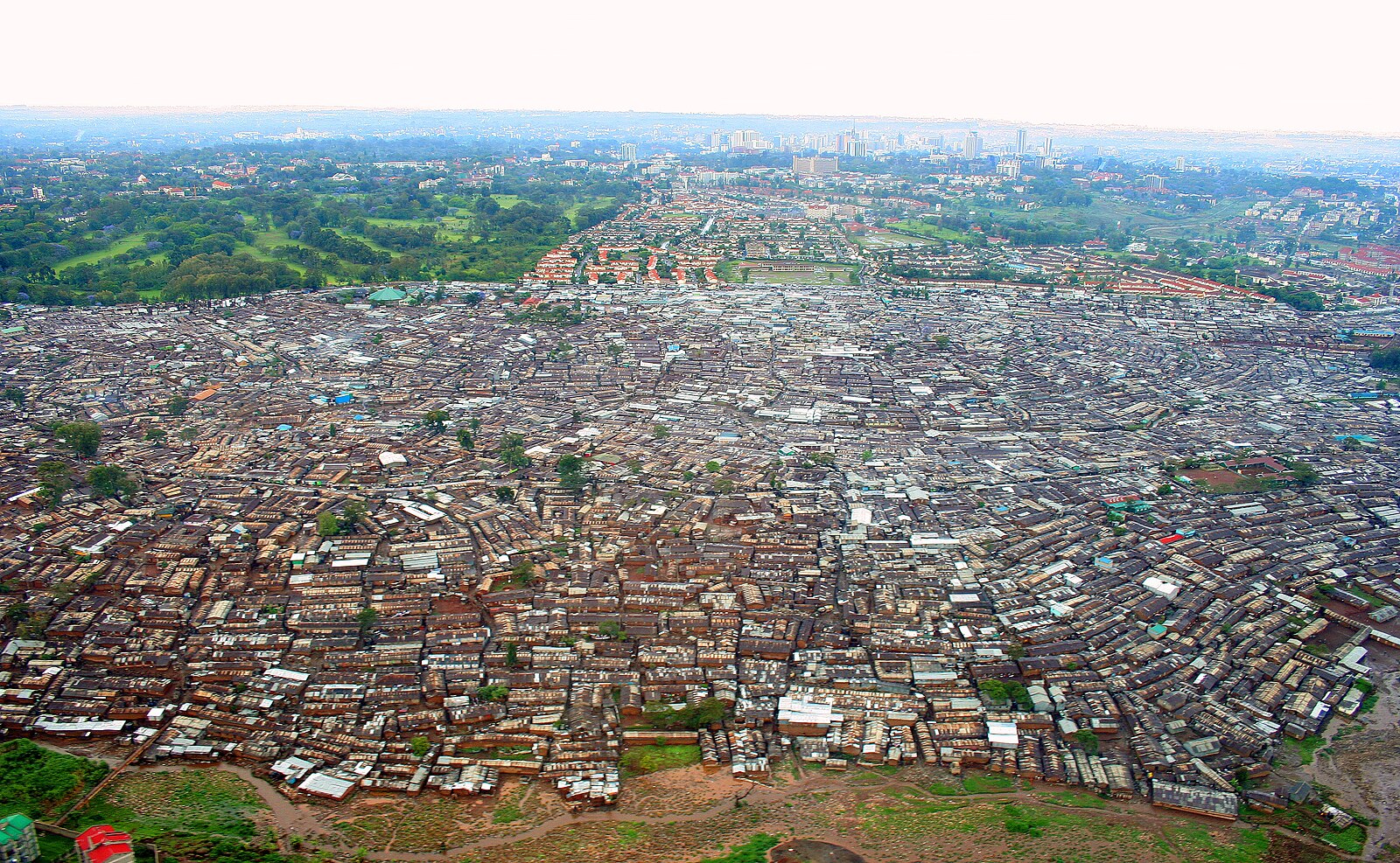 Kenya power and inequality: aerial view of Kibera in Nairobi beside greener neighbourhoods