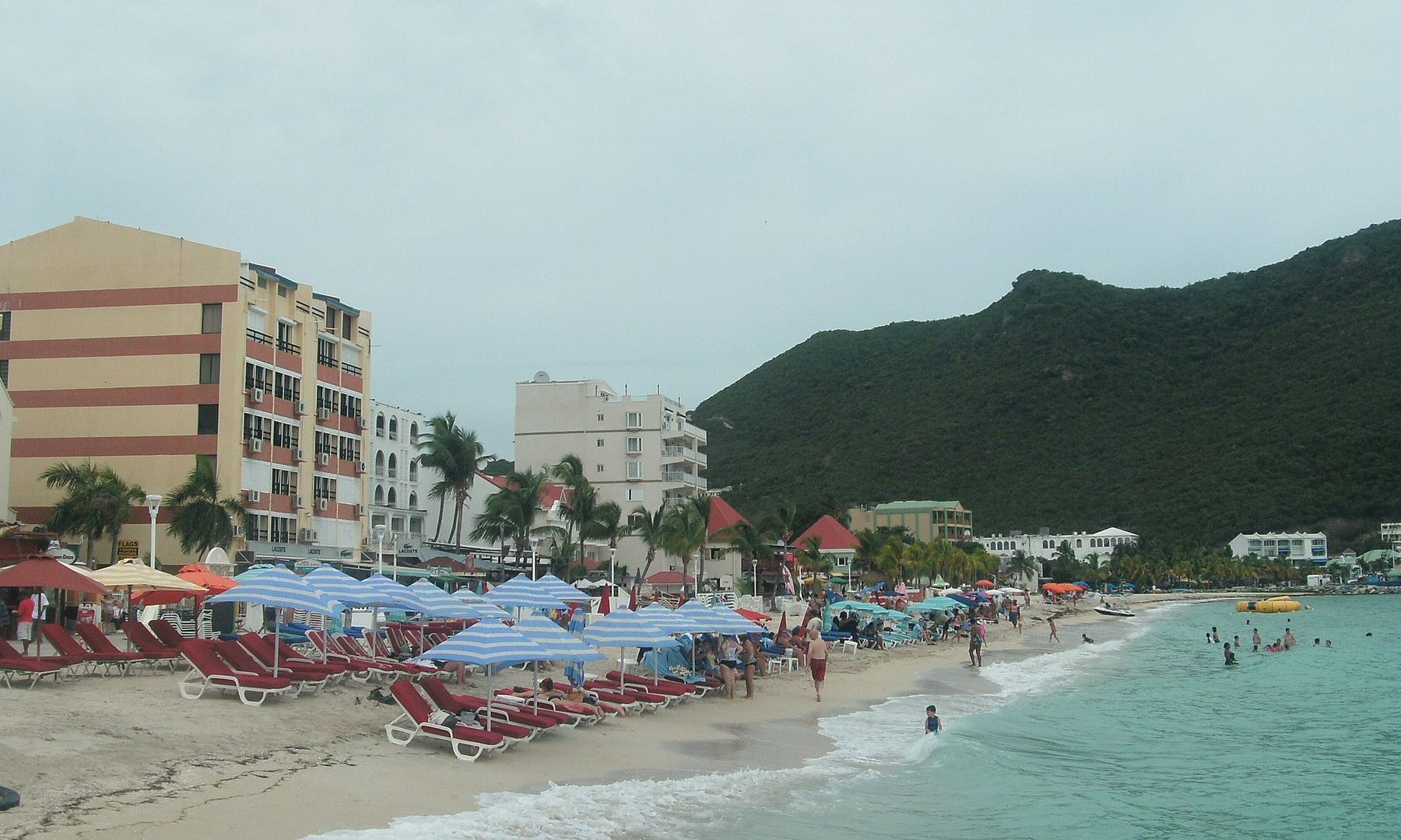 Kingdom Summit host Sint Maarten: the beach at Philipsburg with sun loungers, hotels and green hills