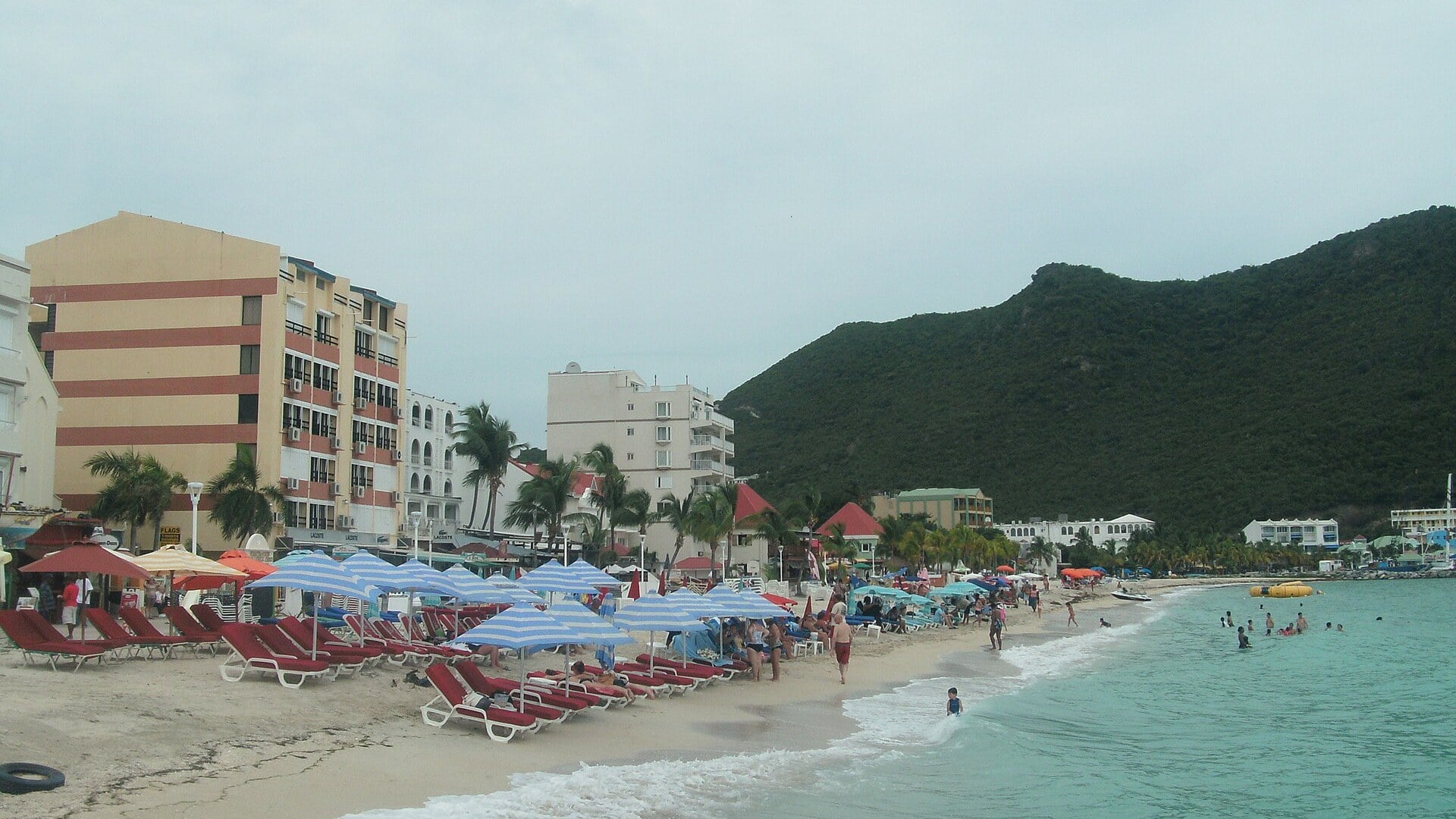 Kingdom Summit host Sint Maarten: the beach at Philipsburg with sun loungers, hotels and green hills