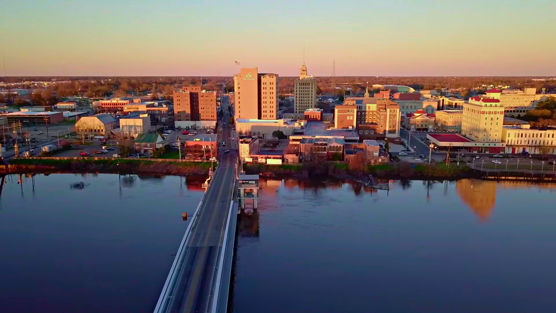Aerial view of downtown Monroe, Louisiana, at dusk with a bridge over the Ouachita River