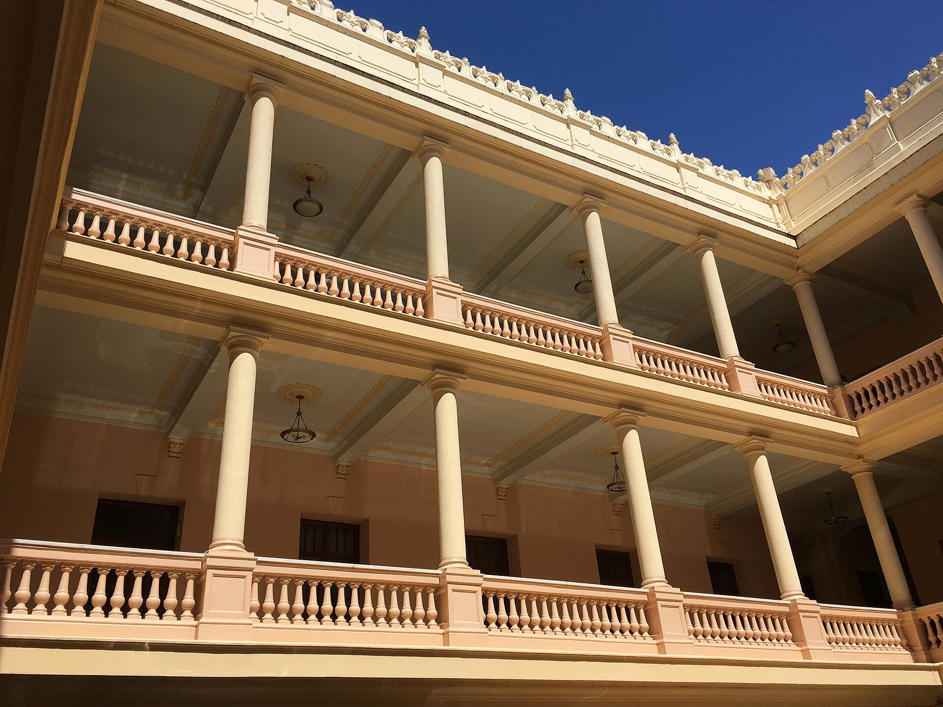 Columned upper galleries around the inner courtyard of the Dominican Republic's National Palace under a blue sky