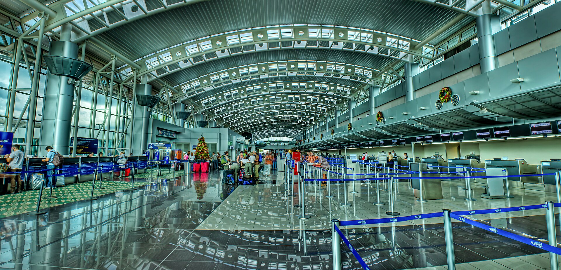 The bright, curved-roof departure hall of Juan Santamaría International Airport with check-in counters