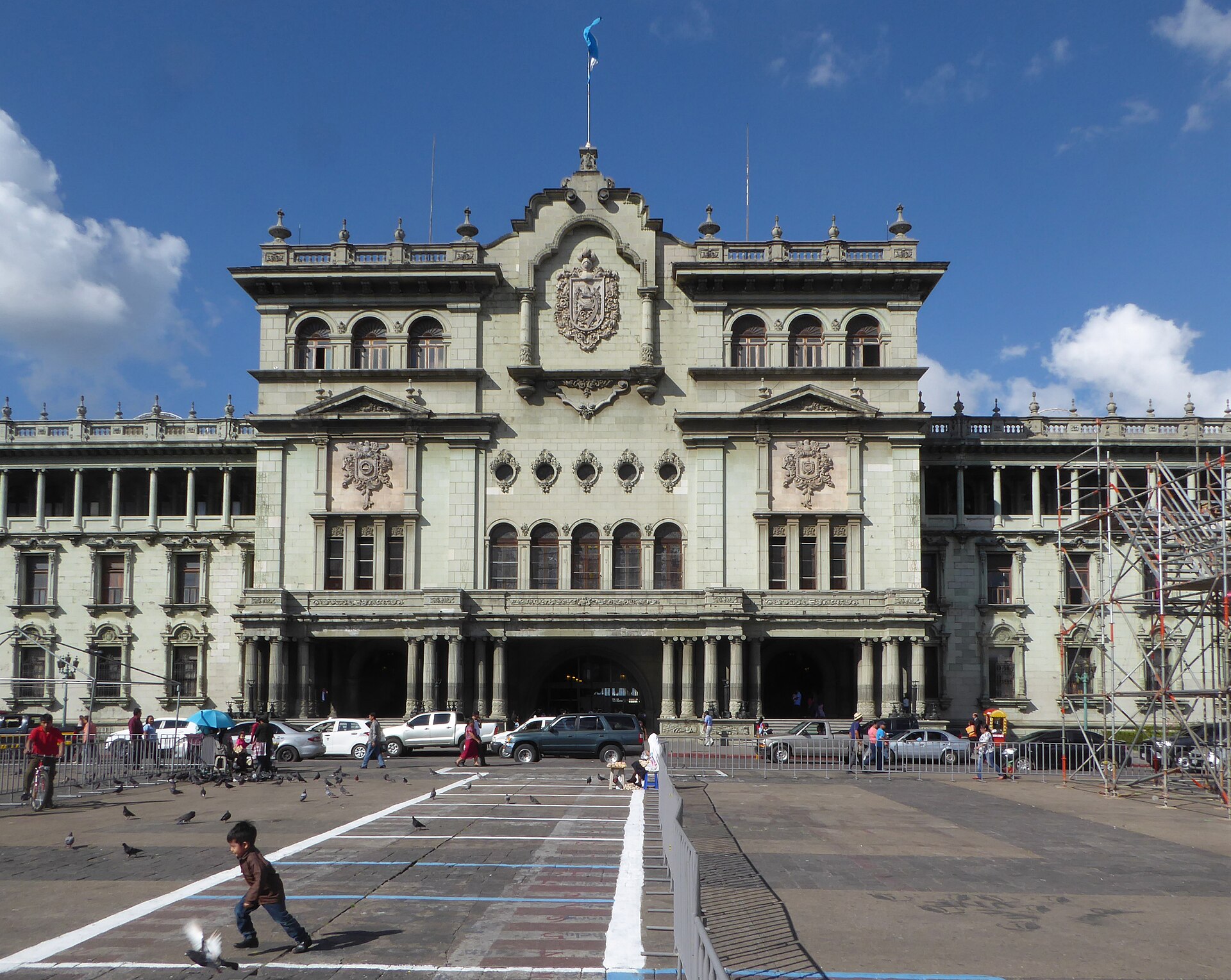 The ornate green-grey facade of Guatemala's National Palace of Culture with a plaza in front