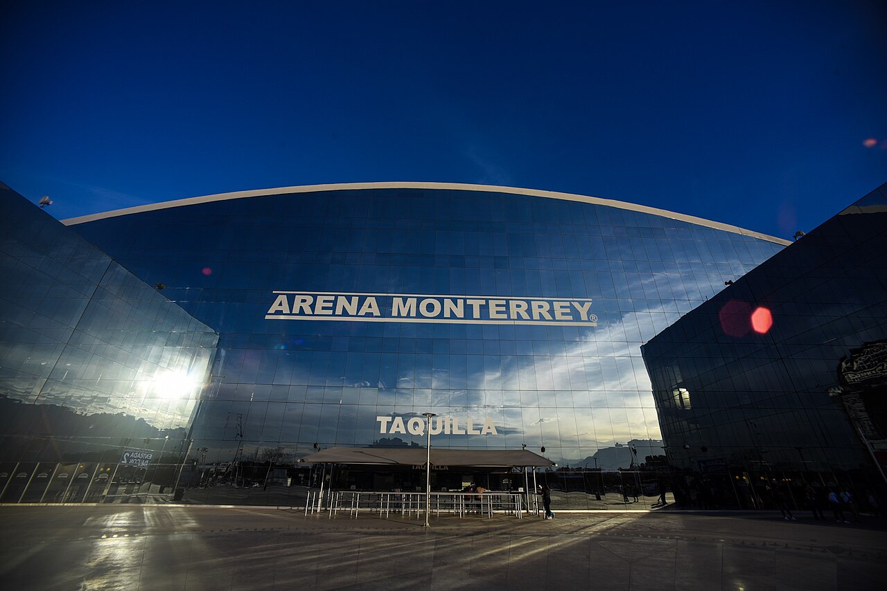 The glass facade of Arena Monterrey at dusk, with the venue name and the word Taquilla, meaning box office, above the ticket windows.