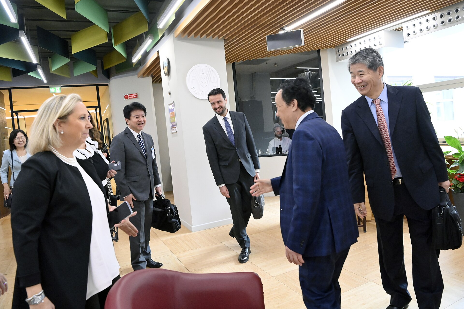 FAO Director-General Qu Dongyu shaking hands with visitors in a lobby at FAO headquarters in Rome