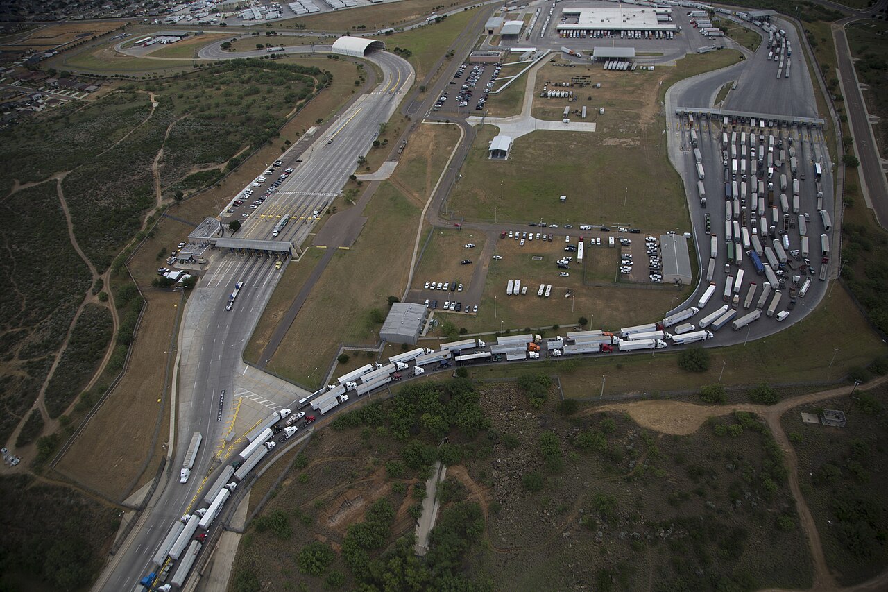 Aerial view of long lines of cargo trucks queuing at inspection lanes of the World Trade Bridge in Laredo, Texas