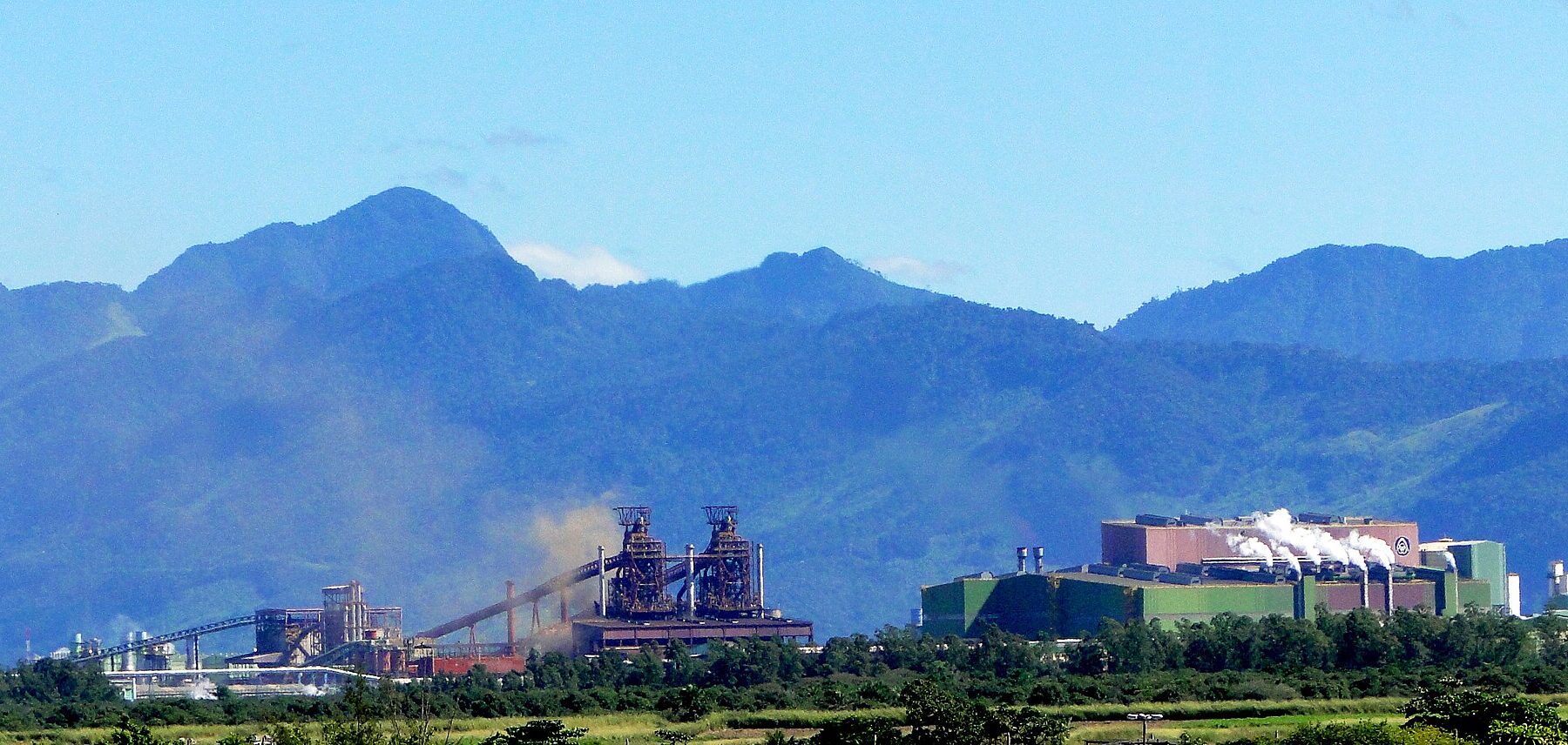 The Ternium Brasil steelworks, formerly CSA, with its blast furnaces at Santa Cruz in Rio de Janeiro's west zone, below green hills.