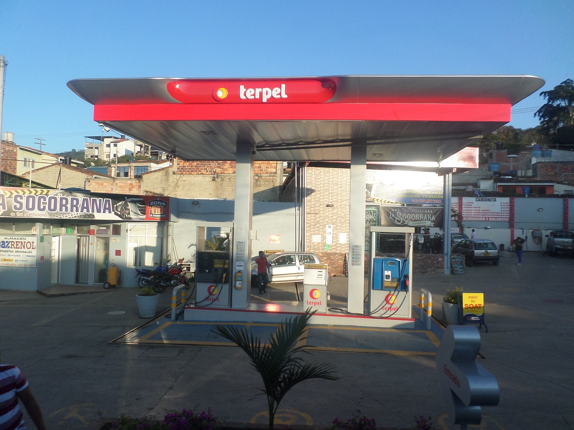 Red-roofed Terpel petrol station with two fuel pumps under a blue sky in Colombia