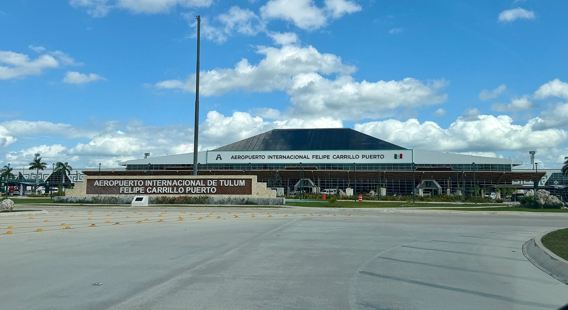 Terminal building of Felipe Carrillo Puerto International Airport in Tulum with its name sign under a blue sky