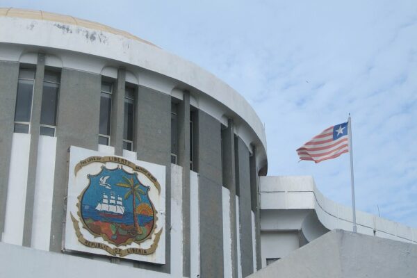 The Capitol Building in Monrovia, Liberia, with the national coat of arms on its curved facade and the Liberian flag flying beside it