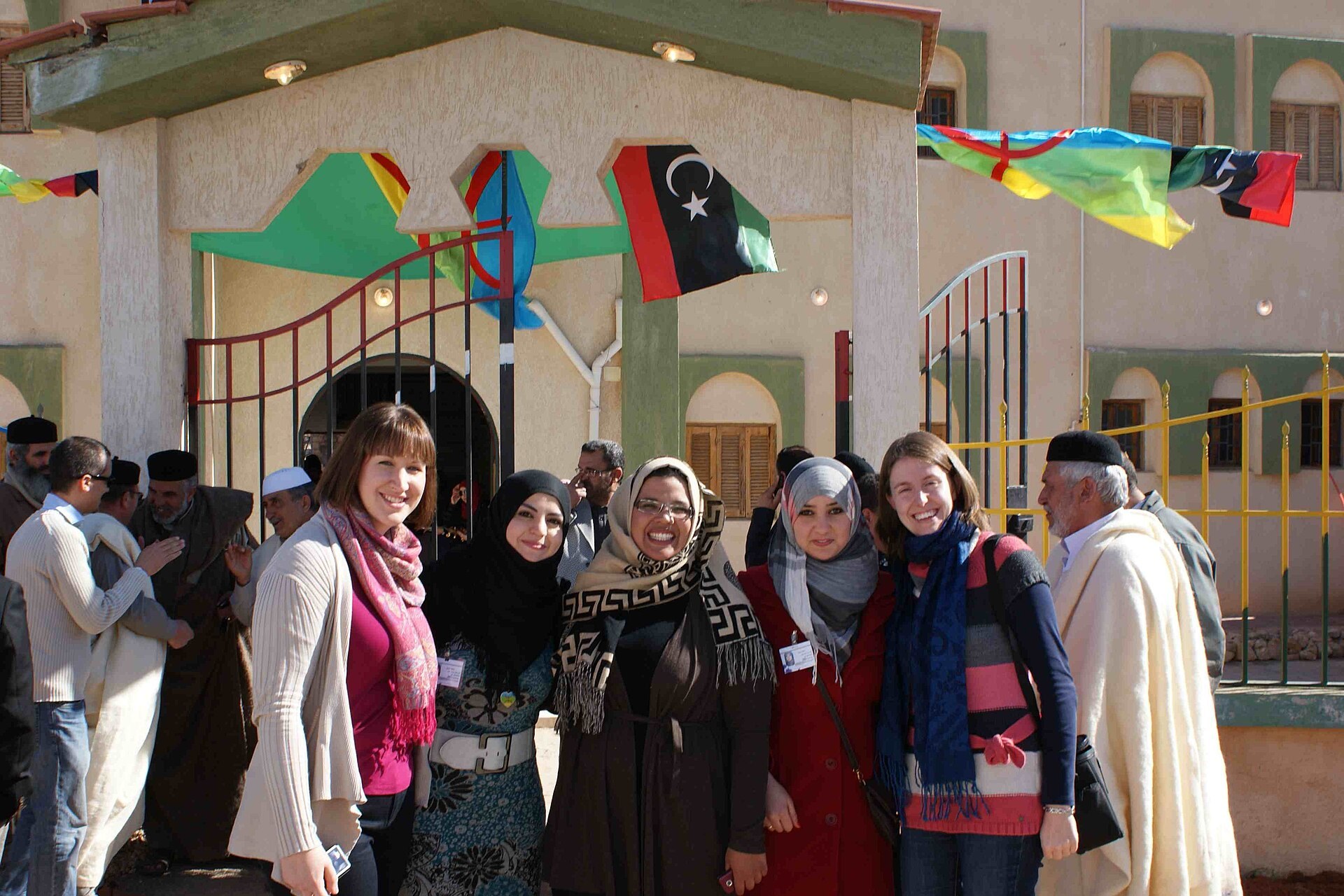 Libyan domestic election observers and programme staff outside a building decorated with Libyan and Amazigh flags