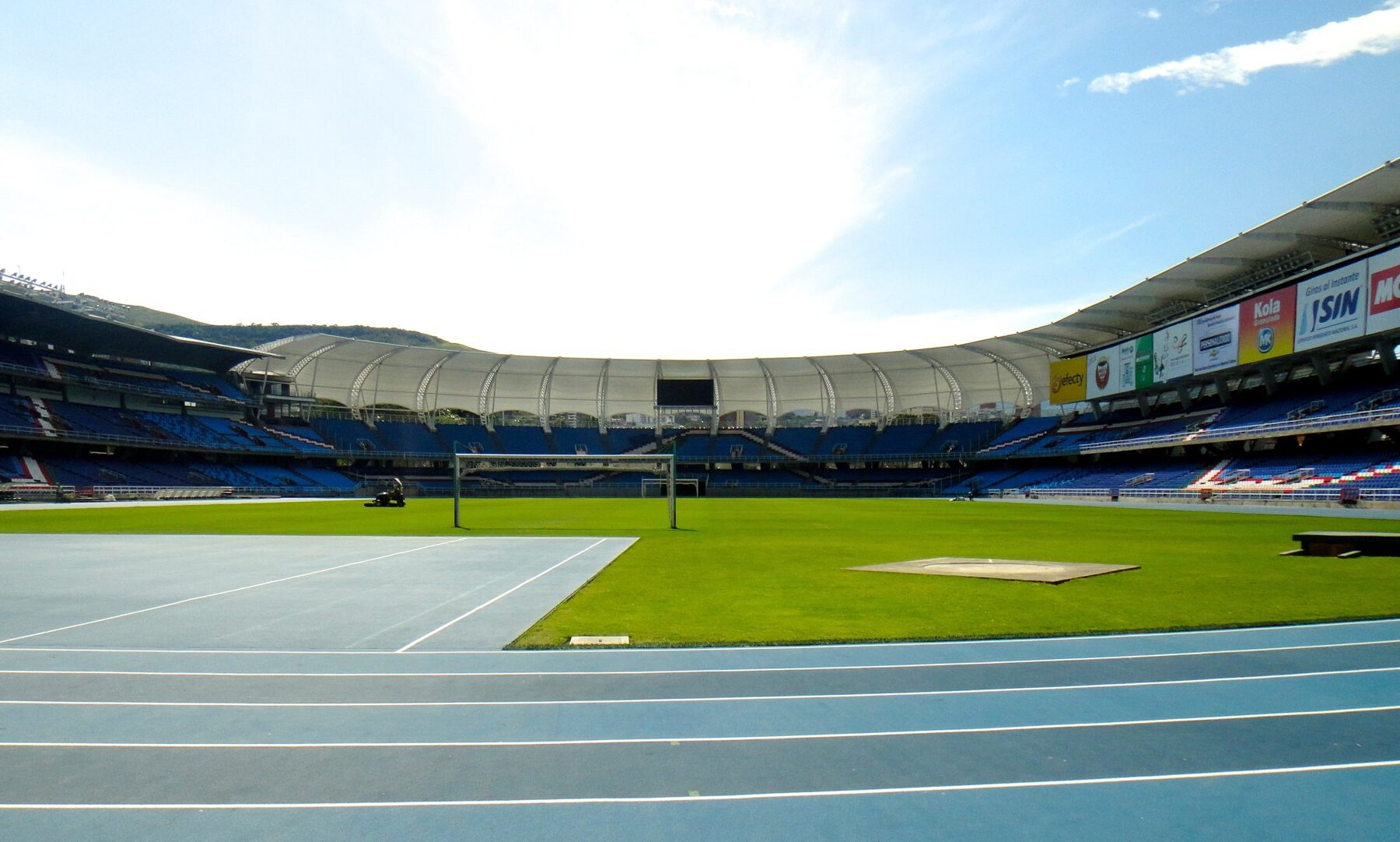 Inside the Estadio Olímpico Pascual Guerrero in Cali, Colombia, with blue seats and a white roof