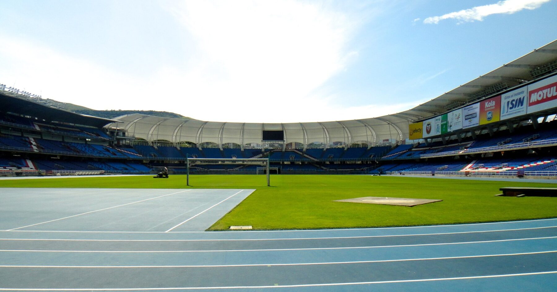 Inside the Estadio Olímpico Pascual Guerrero in Cali, Colombia, with blue seats and a white roof