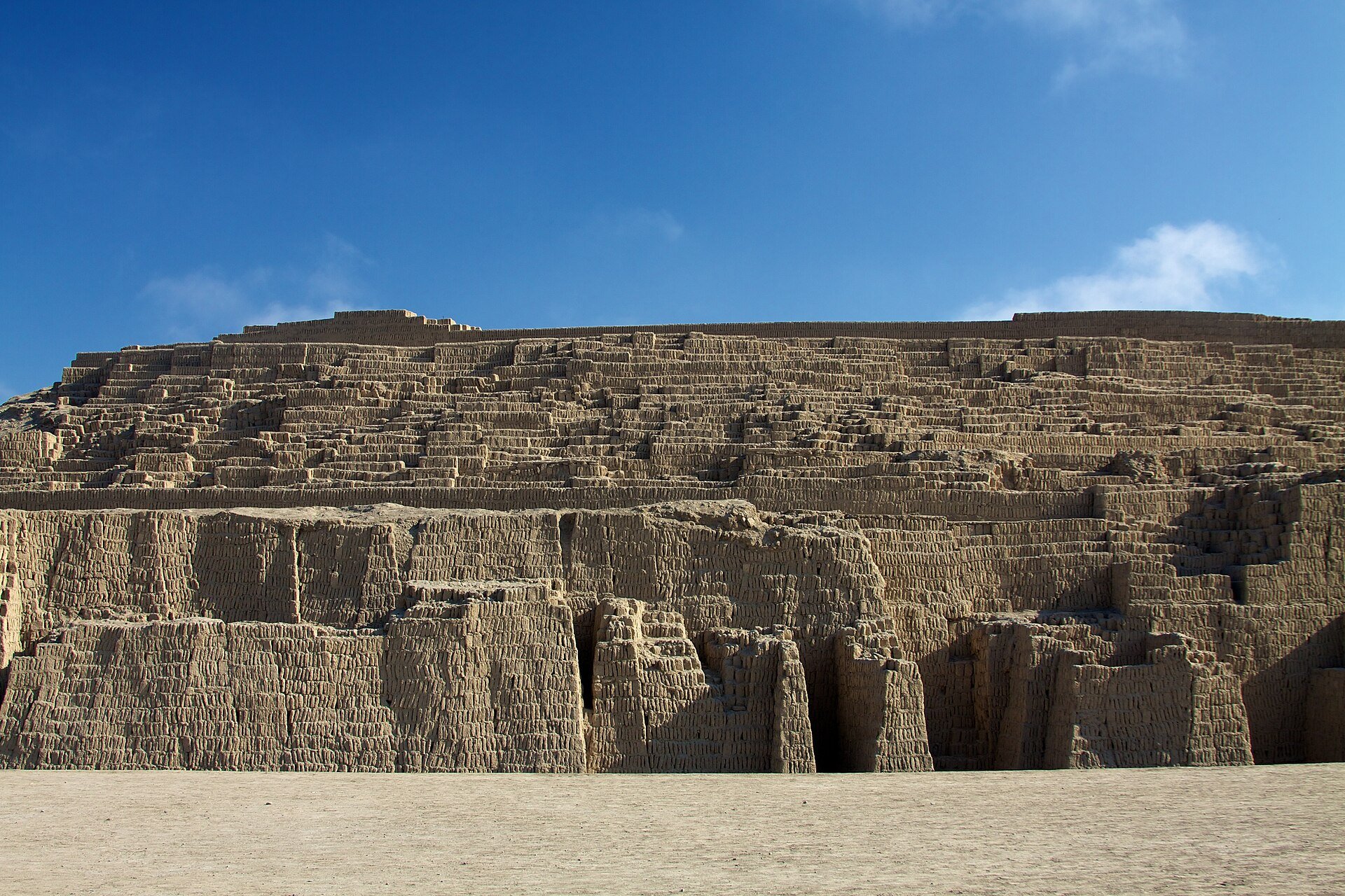 Adobe brick terraces of the Huaca Pucllana pyramid under a blue sky in the Miraflores district of Lima, Peru