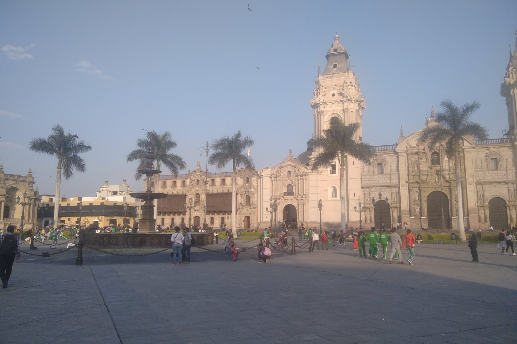 Plaza Mayor of Lima with the fountain, palm trees and the Cathedral tower