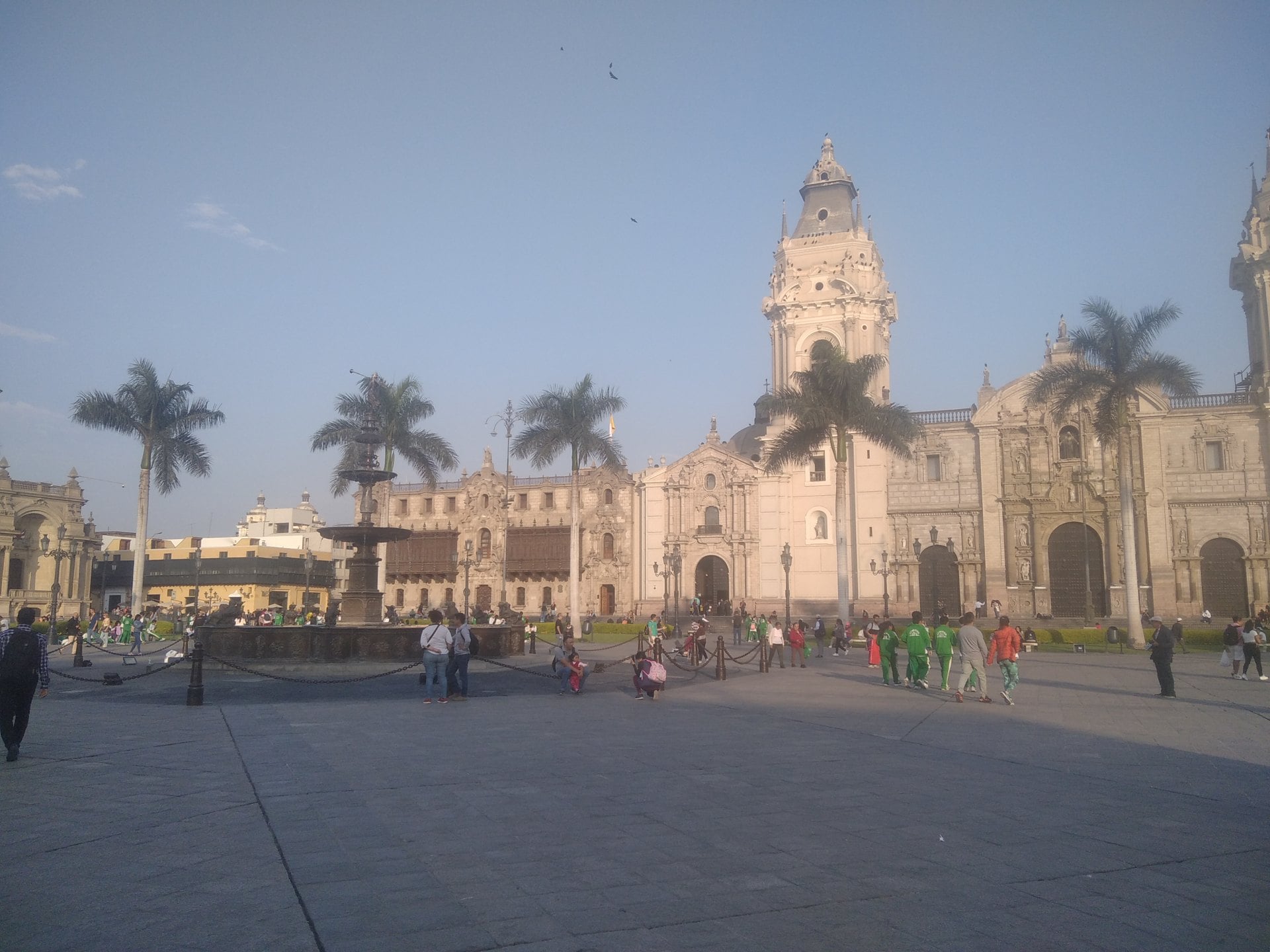 Plaza Mayor of Lima with the fountain, palm trees and the Cathedral tower