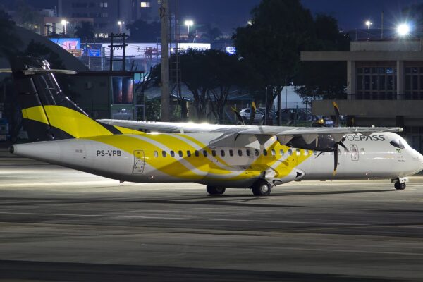 A white ATR 72-500 turboprop with yellow tail livery and VOEPASS titles, registration PS-VPB, parked on an airport apron at night