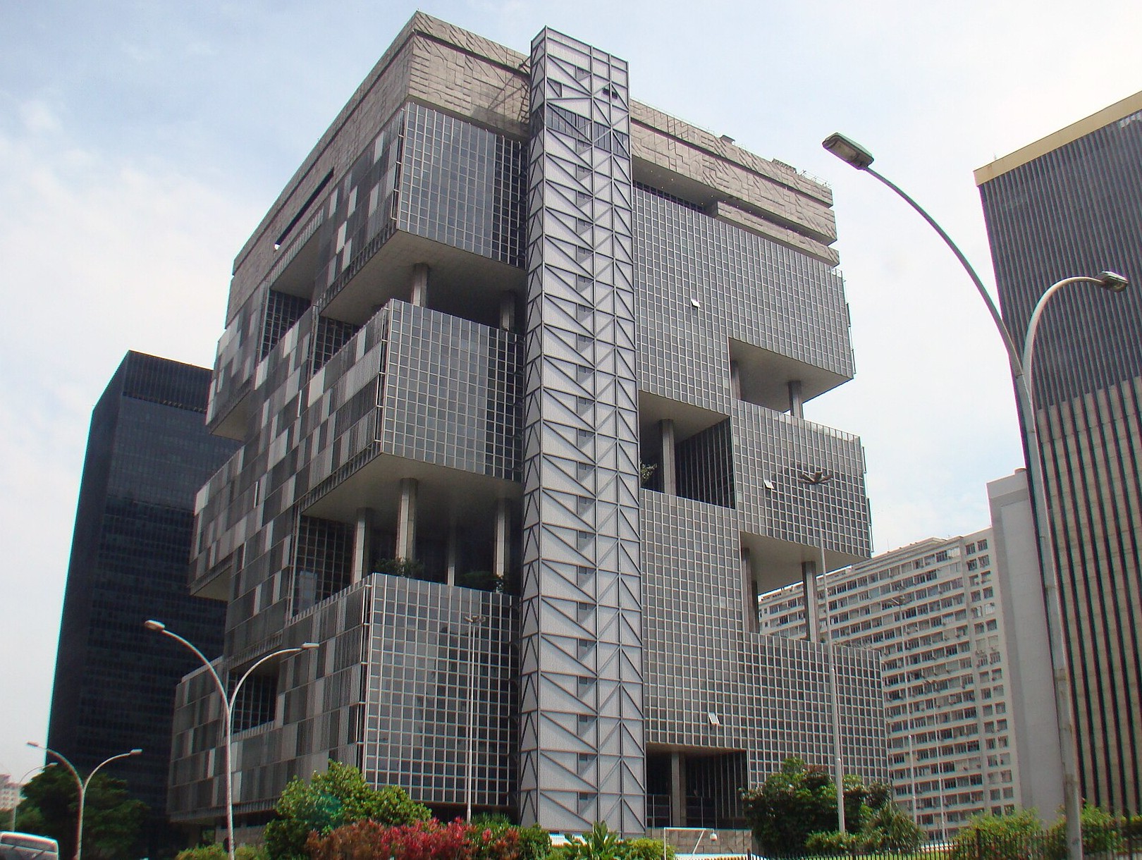 The stepped glass and concrete Petrobras headquarters tower in central Rio de Janeiro seen from street level under a pale sky