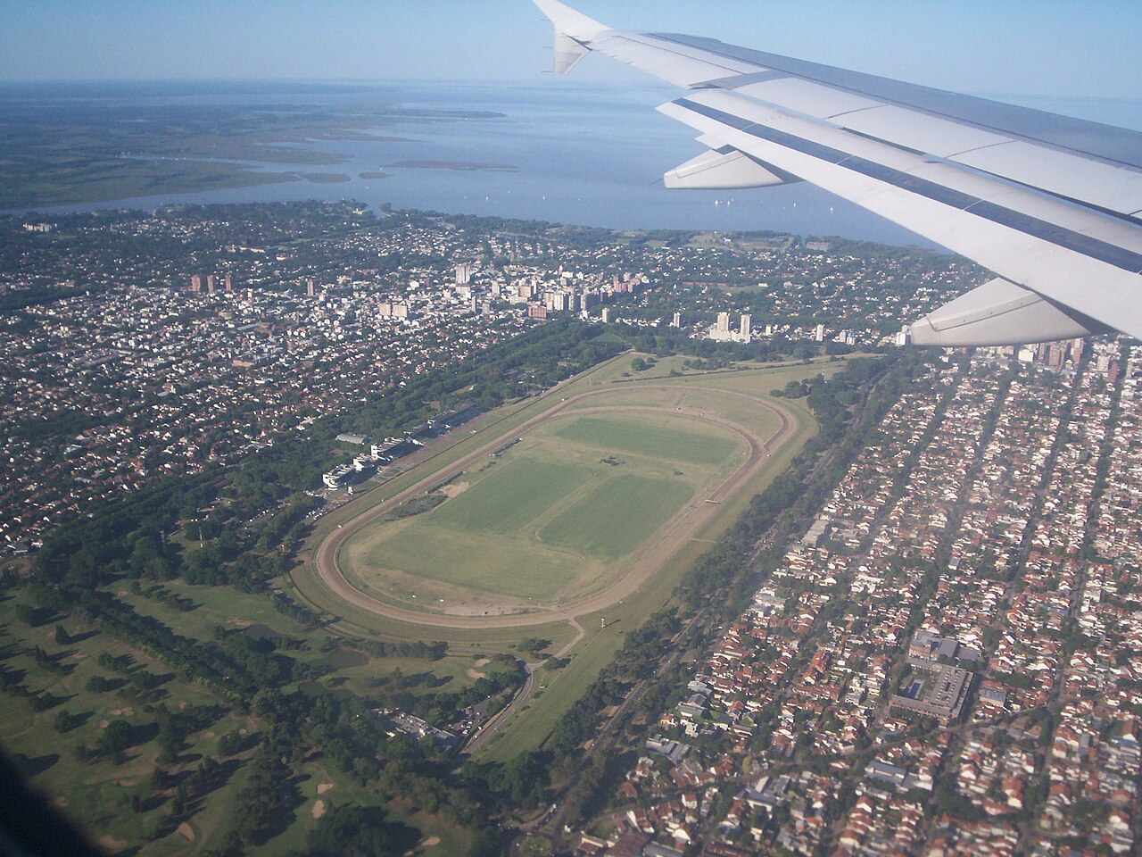 Aerial view from a plane window of the Hipódromo de San Isidro racecourse in a suburb of Buenos Aires, with the Río de la Plata behind.