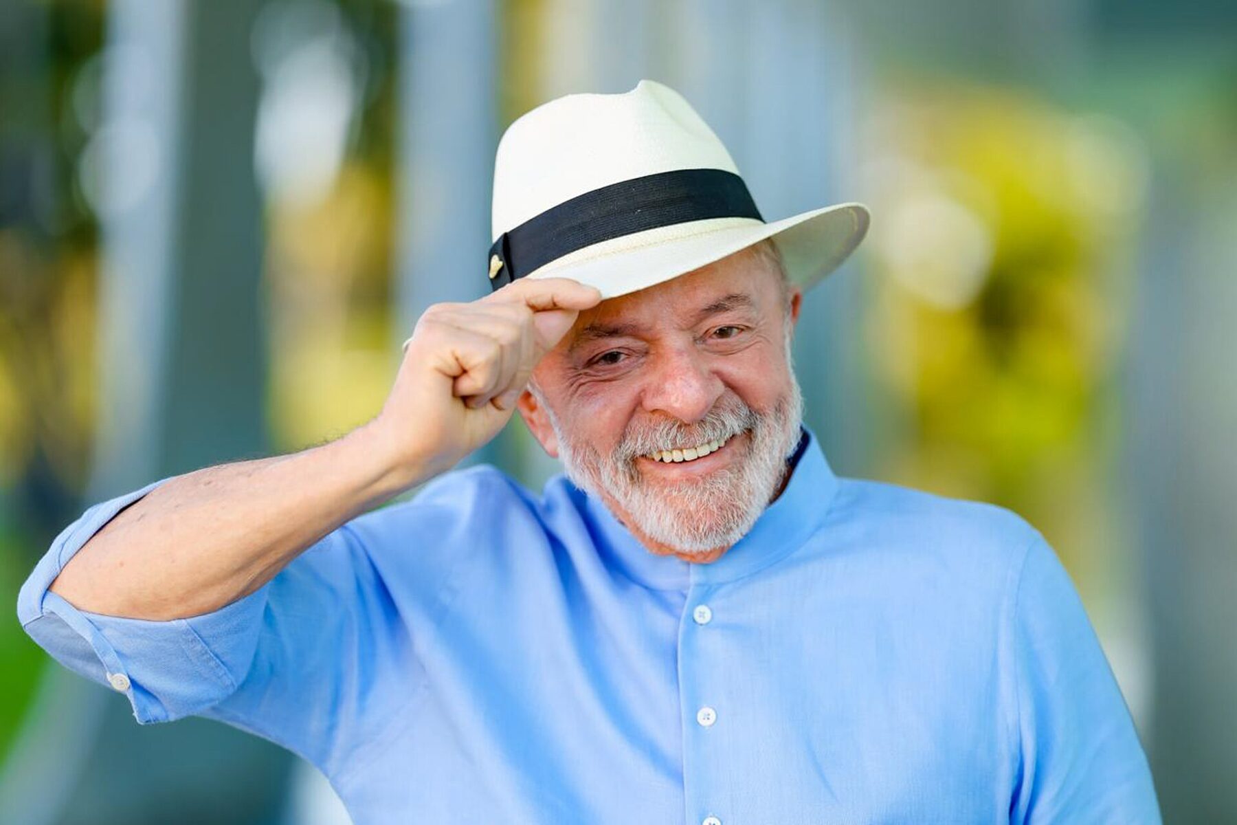 President Lula da Silva in a white hat and light-blue shirt smiling at the Palácio da Alvorada in Brasília