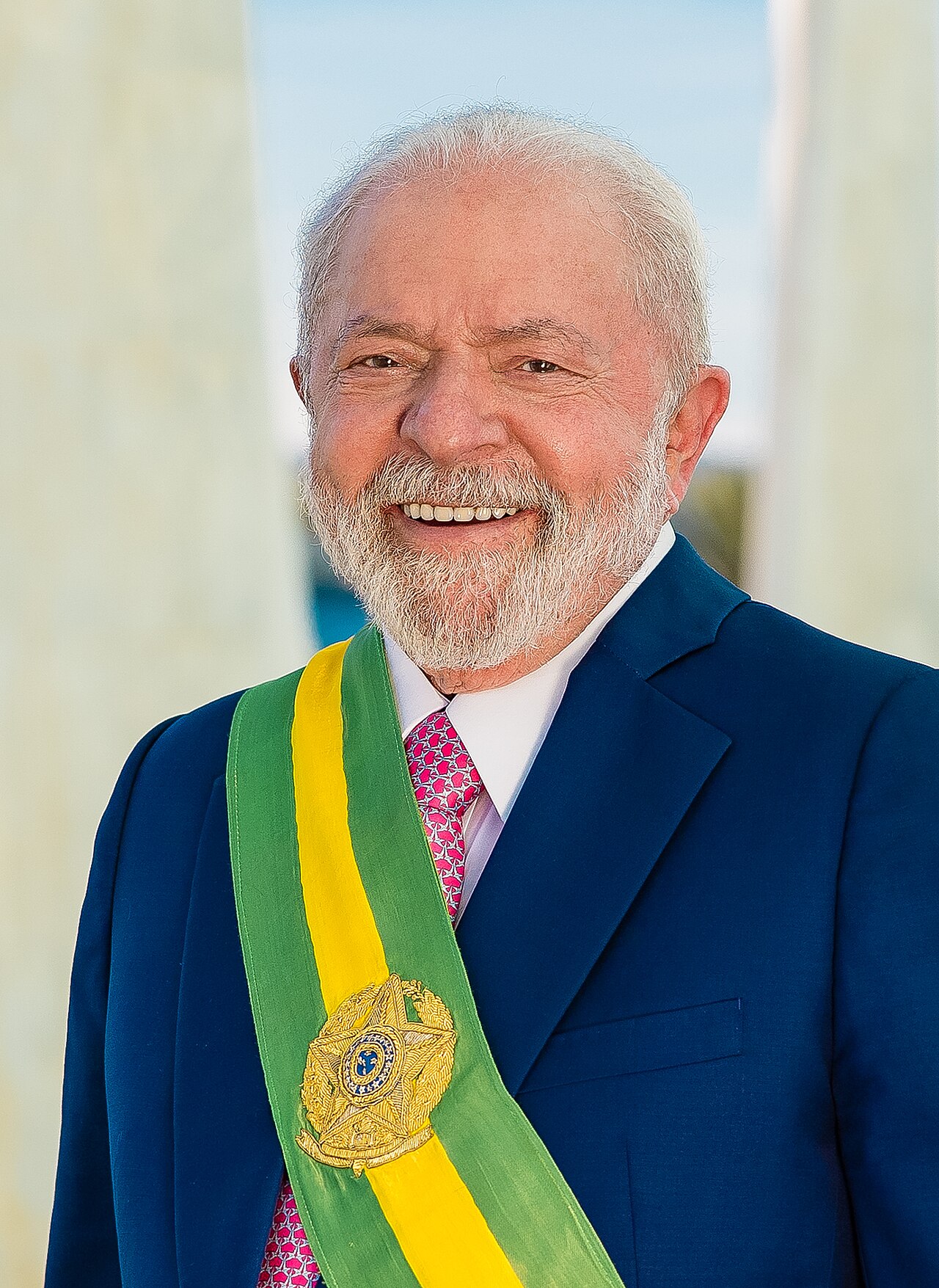 Smiling President Lula in a dark blue suit wearing the green and yellow presidential sash