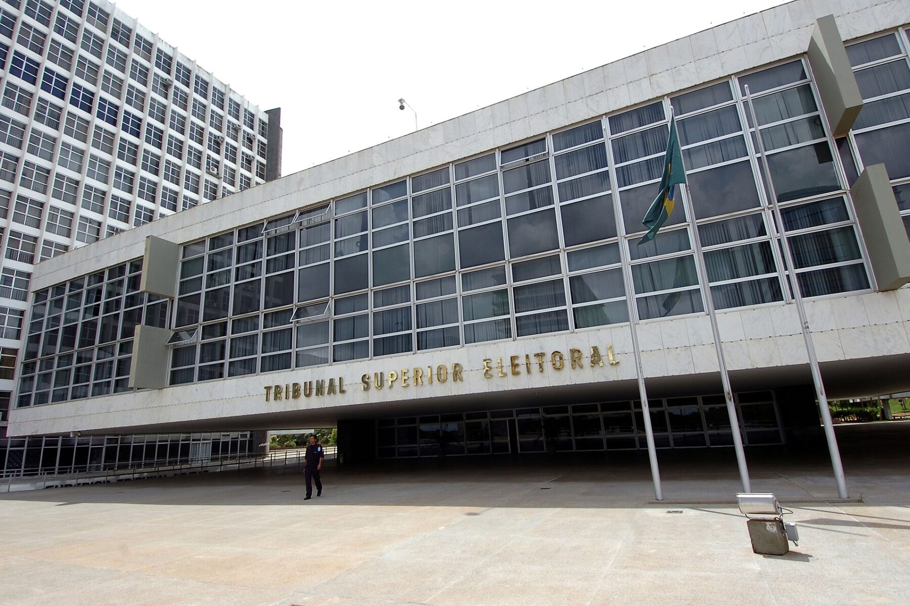 A white modernist building with large glass windows, a Brazilian flag and the words Tribunal Superior Eleitoral on the facade