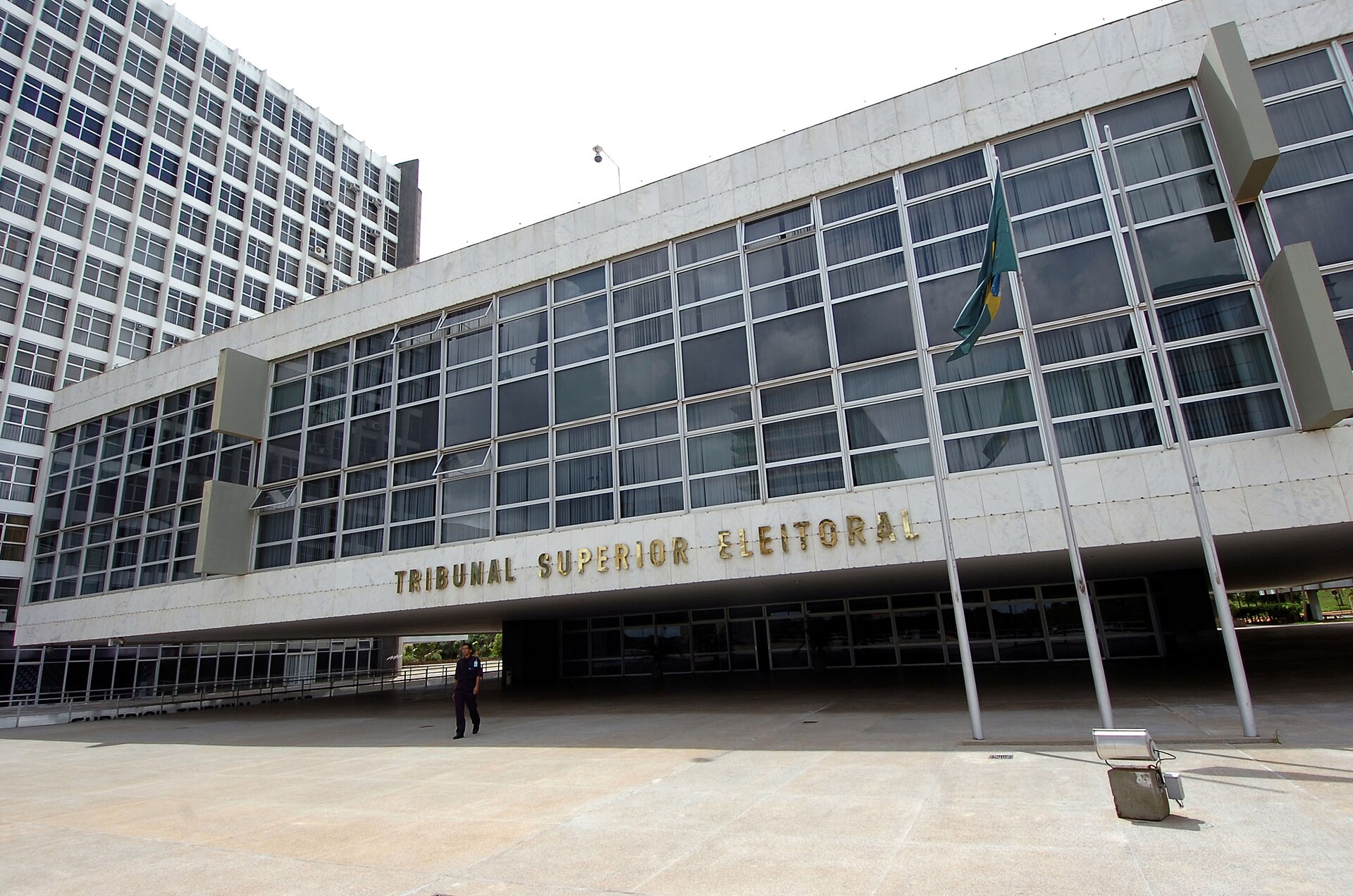 A white modernist building with large glass windows, a Brazilian flag and the words Tribunal Superior Eleitoral on the facade