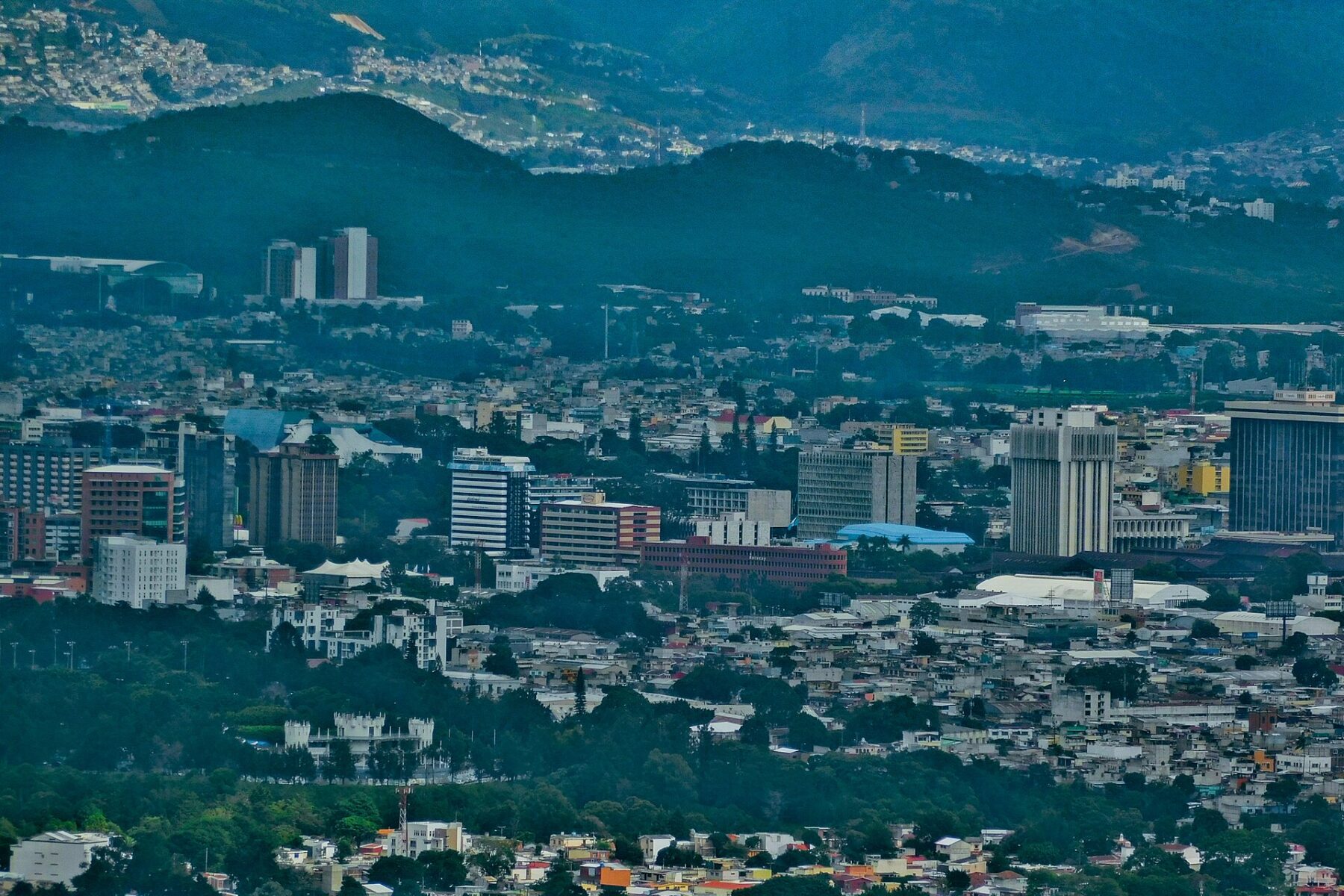 Distant view of Guatemala City with mid-rise office and apartment buildings in front of forested hills