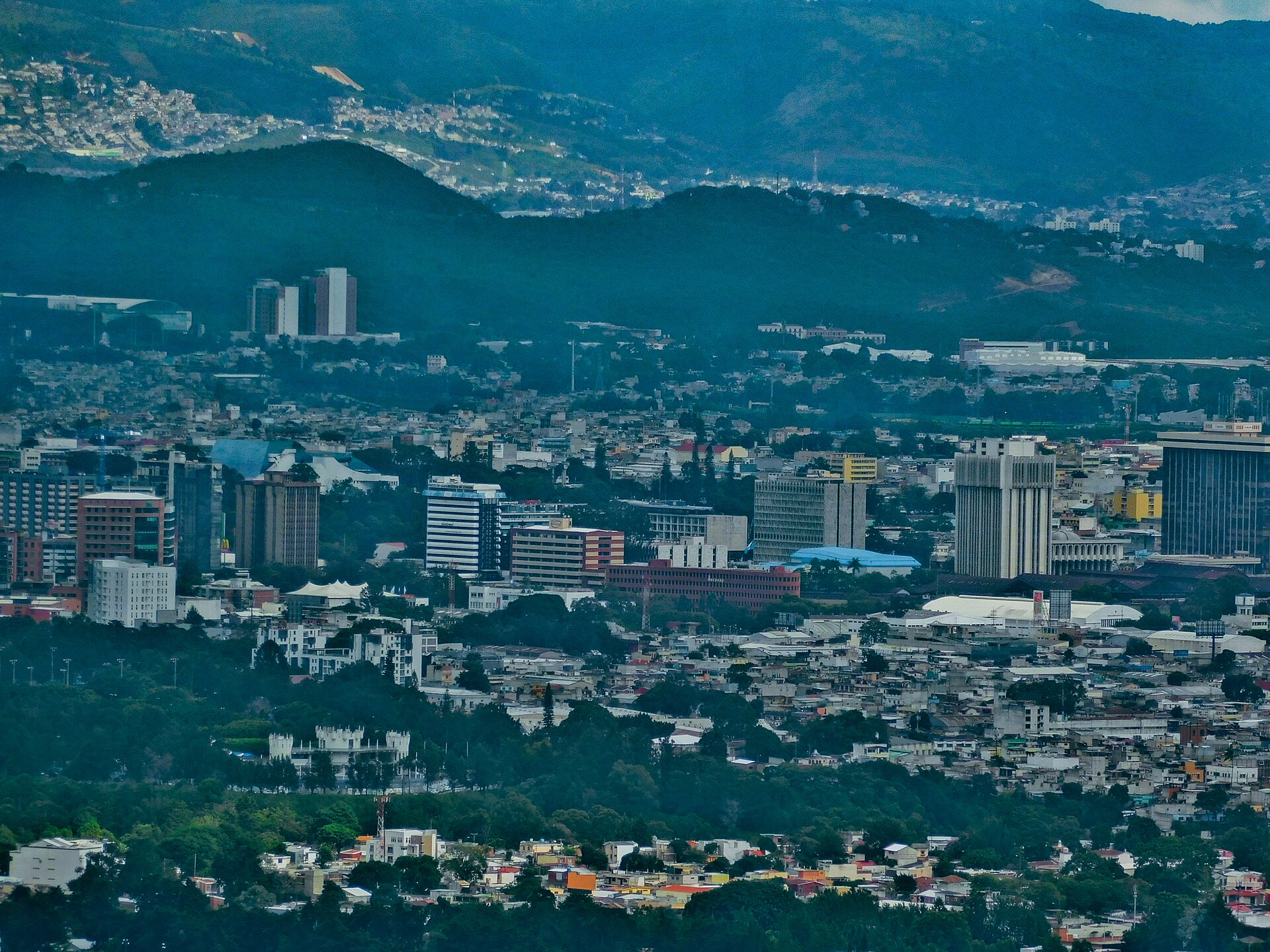 Distant view of Guatemala City with mid-rise office and apartment buildings in front of forested hills