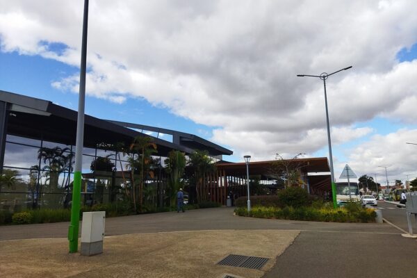 Glass-fronted passenger terminal at Ivato international airport near Antananarivo, with palms and a cloudy sky
