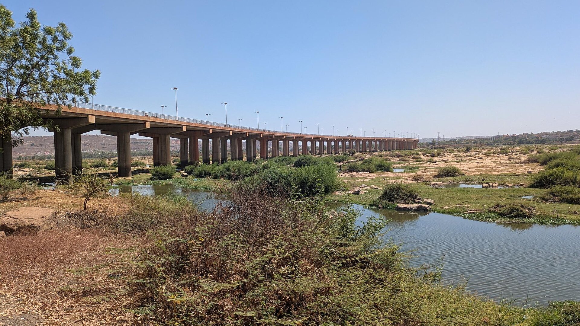 The Third Bridge over the Niger River in Bamako, Mali, a long concrete road bridge seen from the riverbank