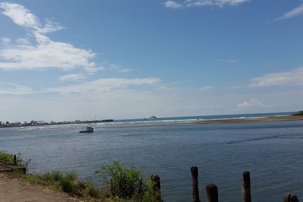 The sea mouth of the harbour at Quepos on the Pacific coast of Costa Rica, with boats on the horizon.