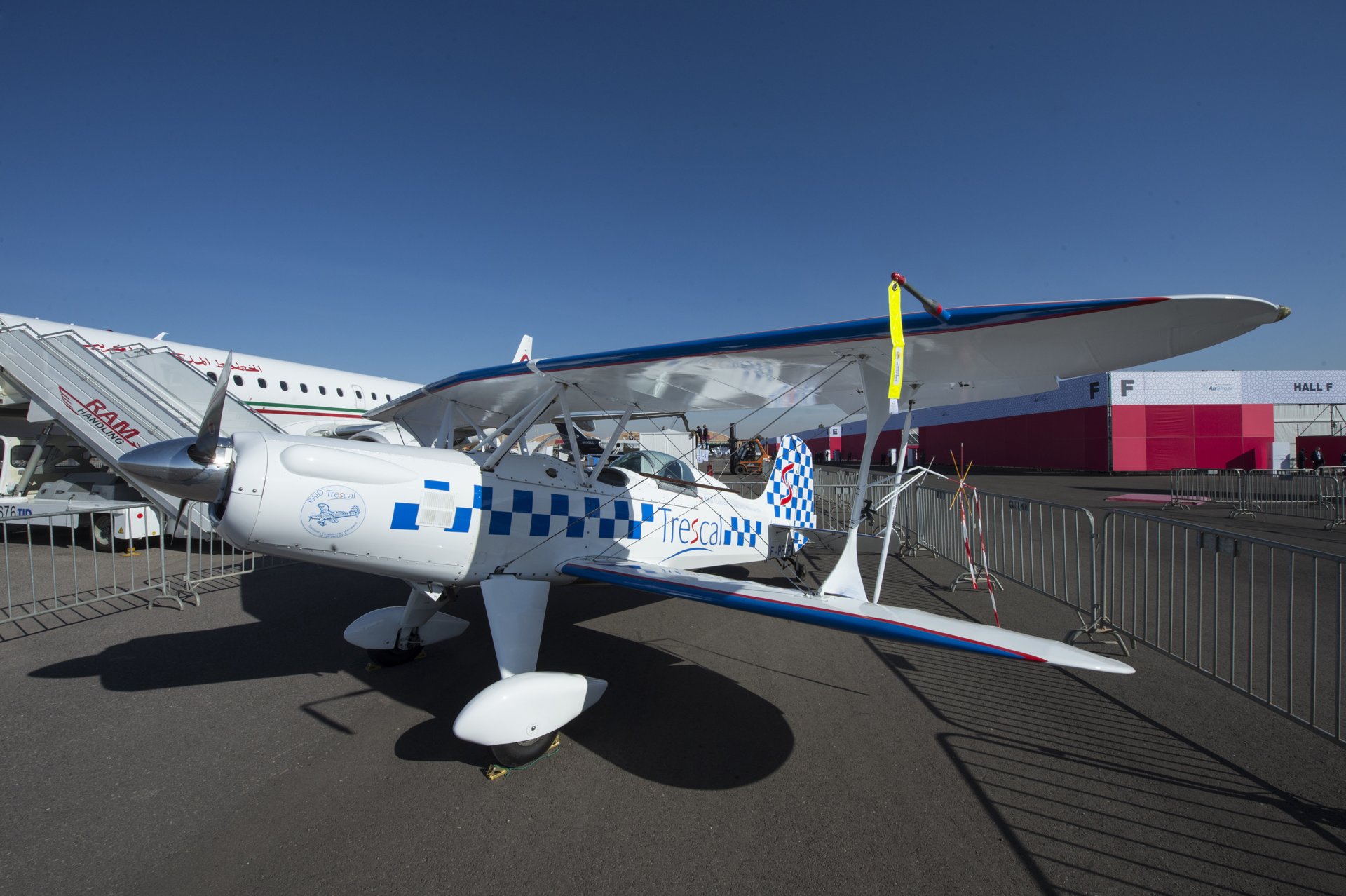 A white biplane parked beside a Royal Air Maroc jet at the Marrakech Air Show
