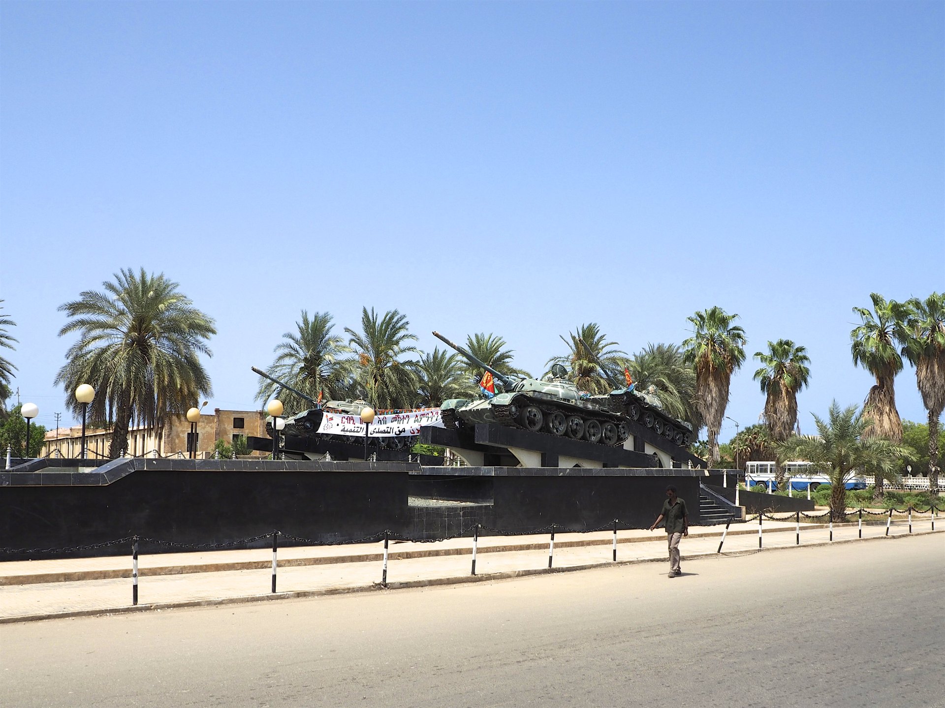 Three tanks mounted on a war memorial among palm trees in Massawa, Eritrea