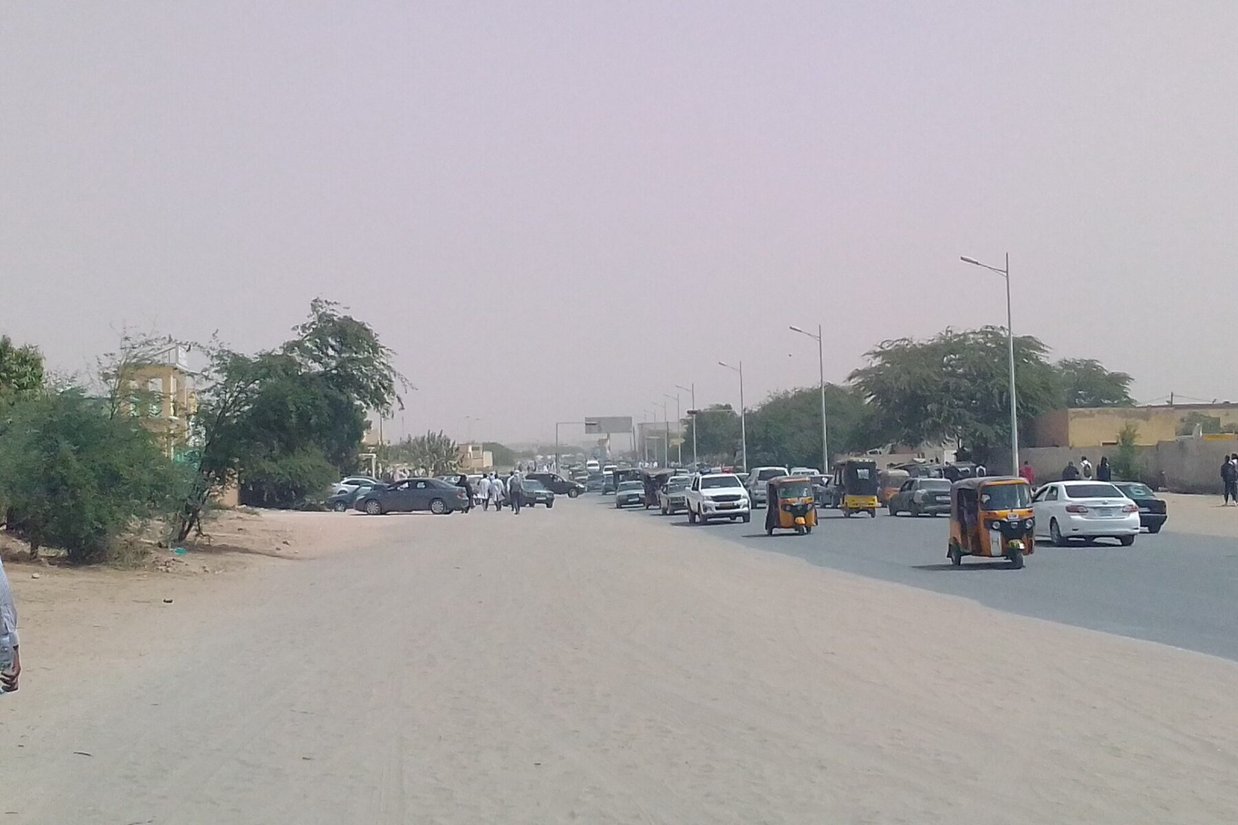 A road with cars and auto-rickshaws in Nouakchott, the capital of Mauritania