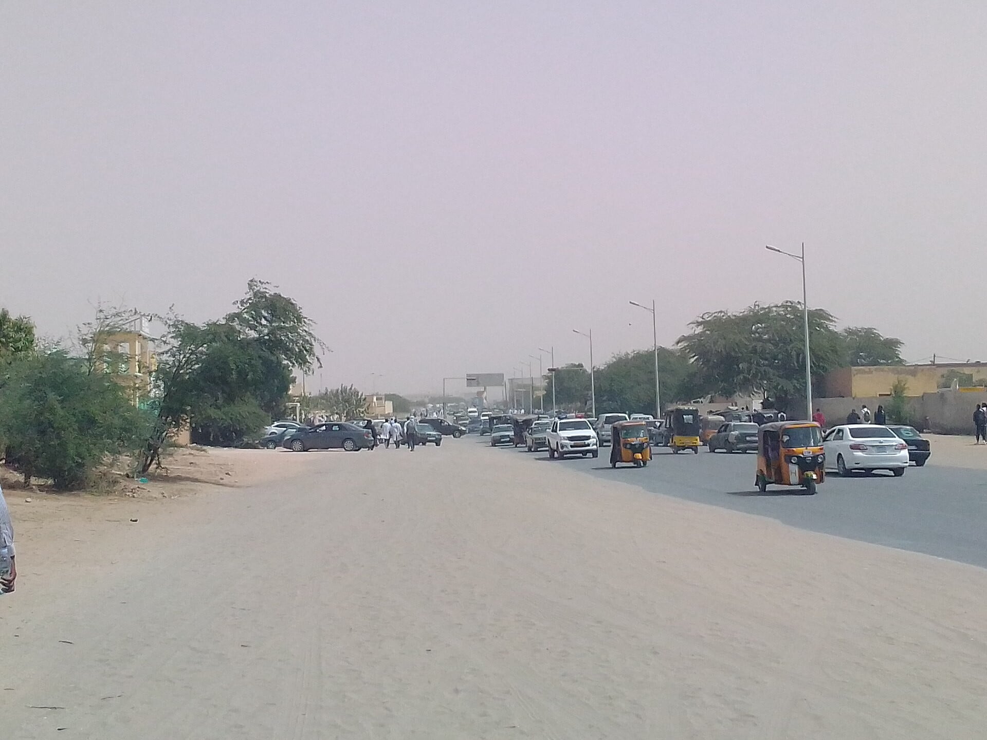 A road with cars and auto-rickshaws in Nouakchott, the capital of Mauritania